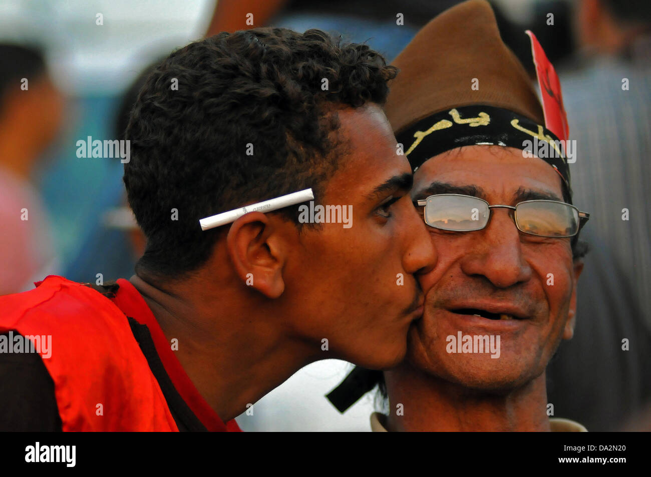 Un jeune homme donne un vieux manifestant un baiser sur la joue lors d'une manifestation contre le président égyptien Morsi à la place Tahrir au Caire, Égypte, 29 juin 2013. Le président égyptien Morsi va célébrer un an à l'office le 30 juin 2013 au milieu des manifestations contre son gouvernement islamiste. Photo : MATTHIAS TOEDT Banque D'Images