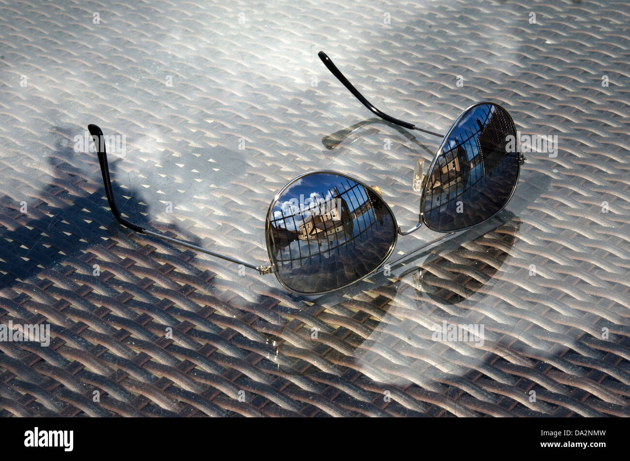 La réflexion des bâtiments et nuages dans lunettes de soleil une table en verre haut northumbria seahouses Banque D'Images