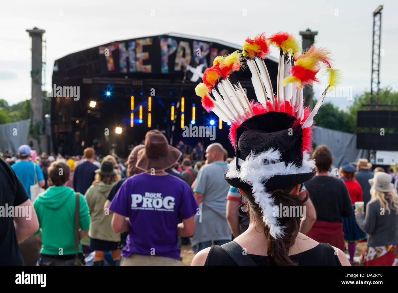 FESTIVAL DE GLASTONBURY, Royaume-Uni - 30 juin 2013 : vue arrière d'une femme portant un chapeau à plumes de couleurs vives à l'étape du Parc Banque D'Images