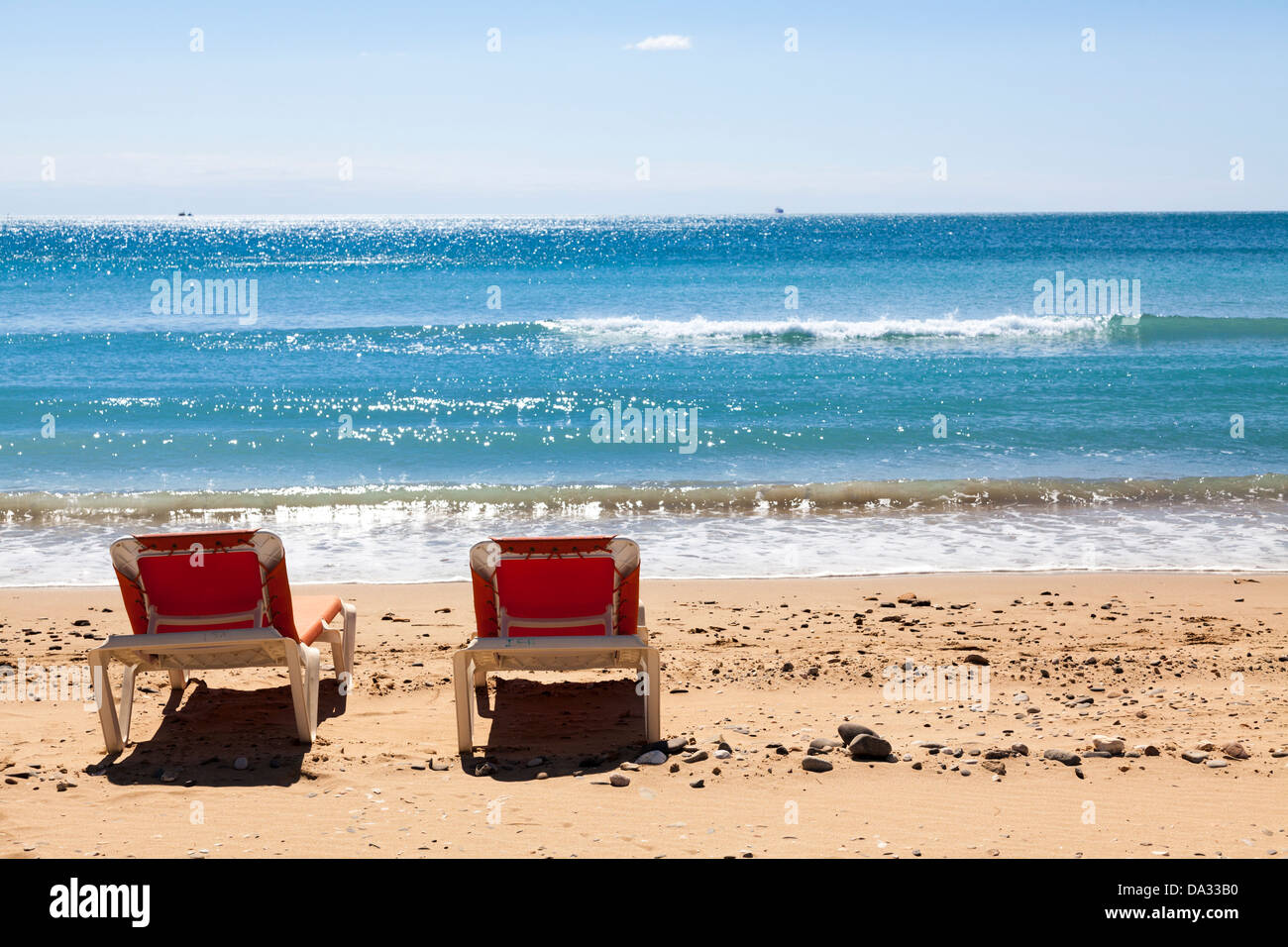 Deux chaises longues sur la plage par la mer Banque D'Images