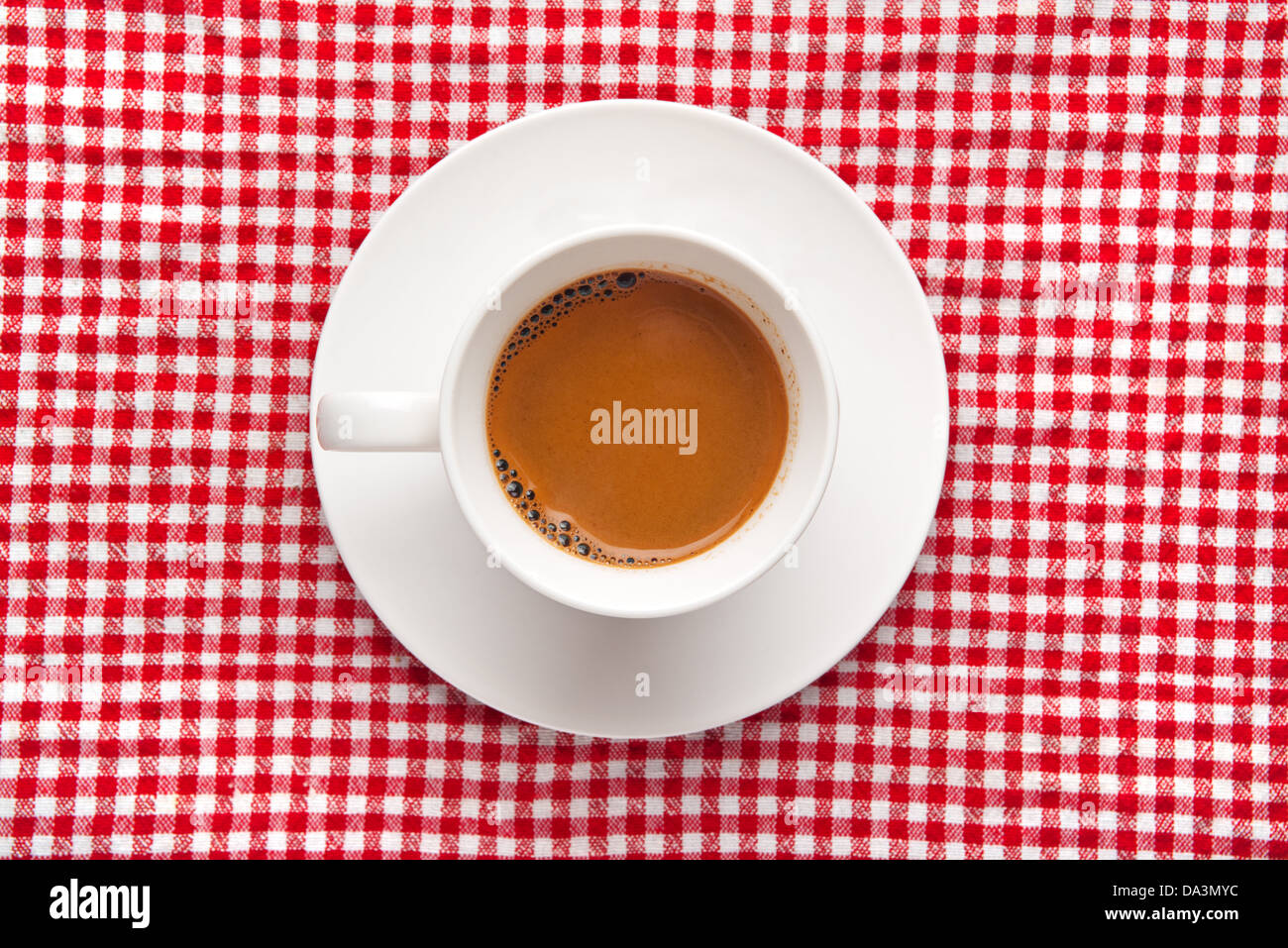 Tasse de café sur la table. Tasse de café noir à damier blanc et rouge ob table cloth arrière-plan. Banque D'Images