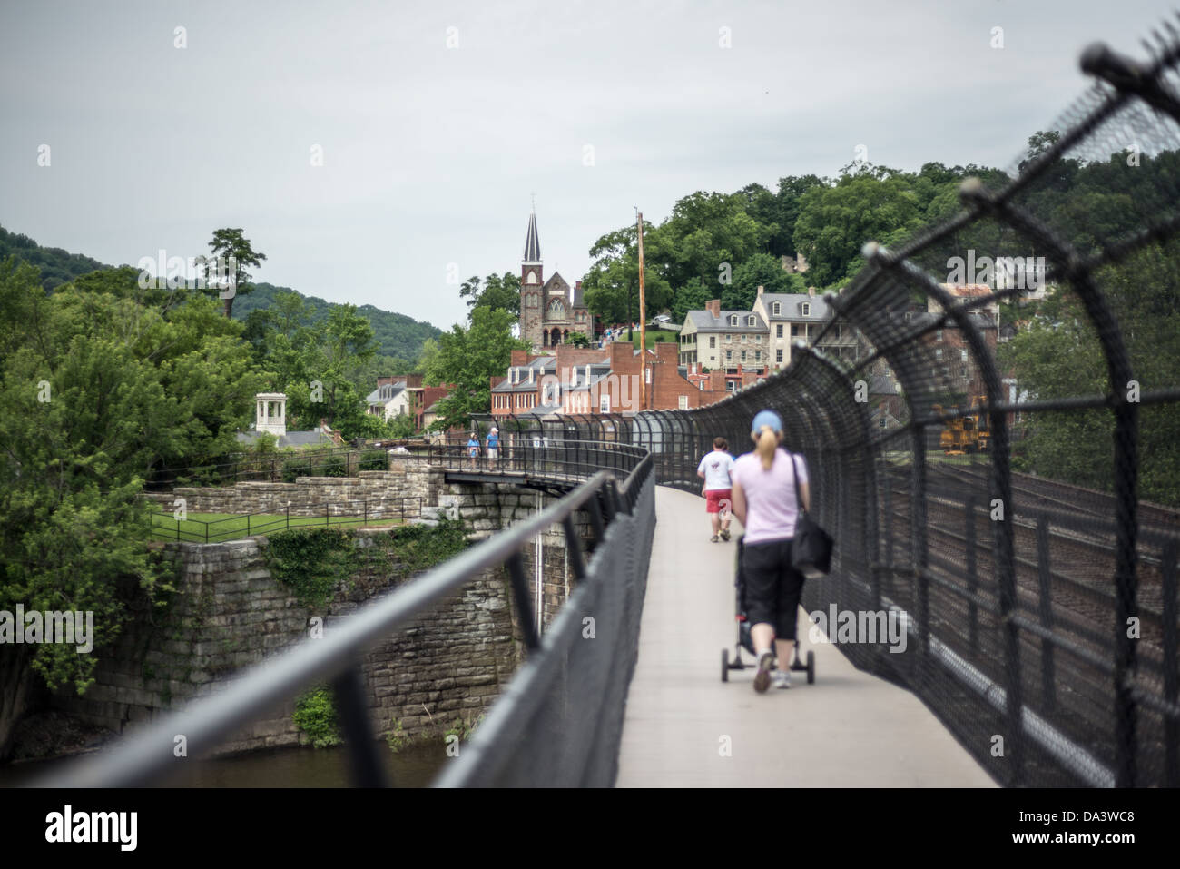 HARPERS FERRY, Virginie-occidentale, États-Unis — Une passerelle publique sur un pont ferroviaire réaménagé enjambe le fleuve Potomac à Harpers Ferry, Virginie-occidentale. Orienté vers l'ouest vers la ville historique, le pont offre aux piétons et aux randonneurs de la piste des Appalaches des vues panoramiques sur la confluence des rivières Potomac et Shenandoah, entourées par les Blue Ridge Mountains. Banque D'Images