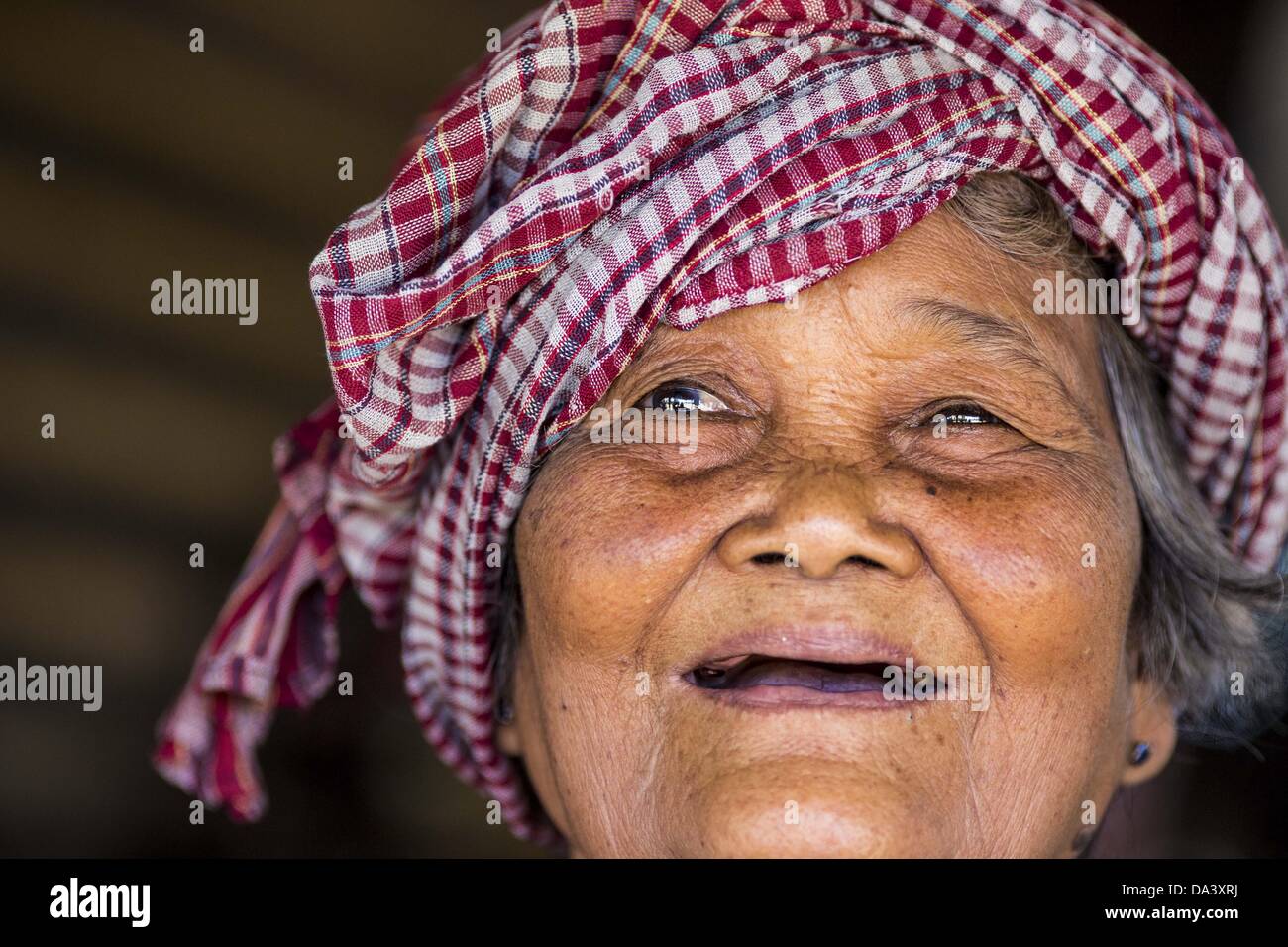 30 juin 2013 - Battambang, Battambang, Cambodge - une femme de 77 ans qui vend des collations et des boissons sur le côté de la voie ferrée de bambou près de Battambang. Le train de bambou, appelé norry (nori) en khmer est a 3m de long, couvert à charpente de bois de la longueur avec lamelles en bois faite de bambou ultra-léger, qui repose sur deux bogies barbell-like, l'aft l'un relié par une courroie de ventilateur pour un moteur à essence de 6CV. Le train passe sur les voies initialement fixées par les Français, lorsque le Cambodge était une colonie française. Des années de guerre et de négligence ont fait les pistes dangereuses pour les trains réguliers. Les Cambodgiens mis 10 ou 15 personnes sur chaque un ou jusqu't Banque D'Images