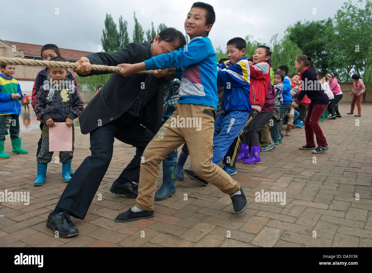 Les élèves des écoles primaires prennent part à une lutte à la corde dans la concurrence Haiyuan, région autonome hui du Ningxia en Chine. 21-mai-2013 Banque D'Images