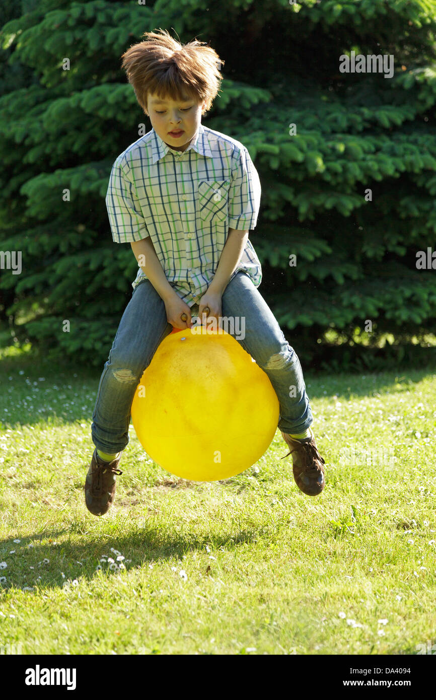 Jeune garçon à l'autre avec un space hopper Banque D'Images