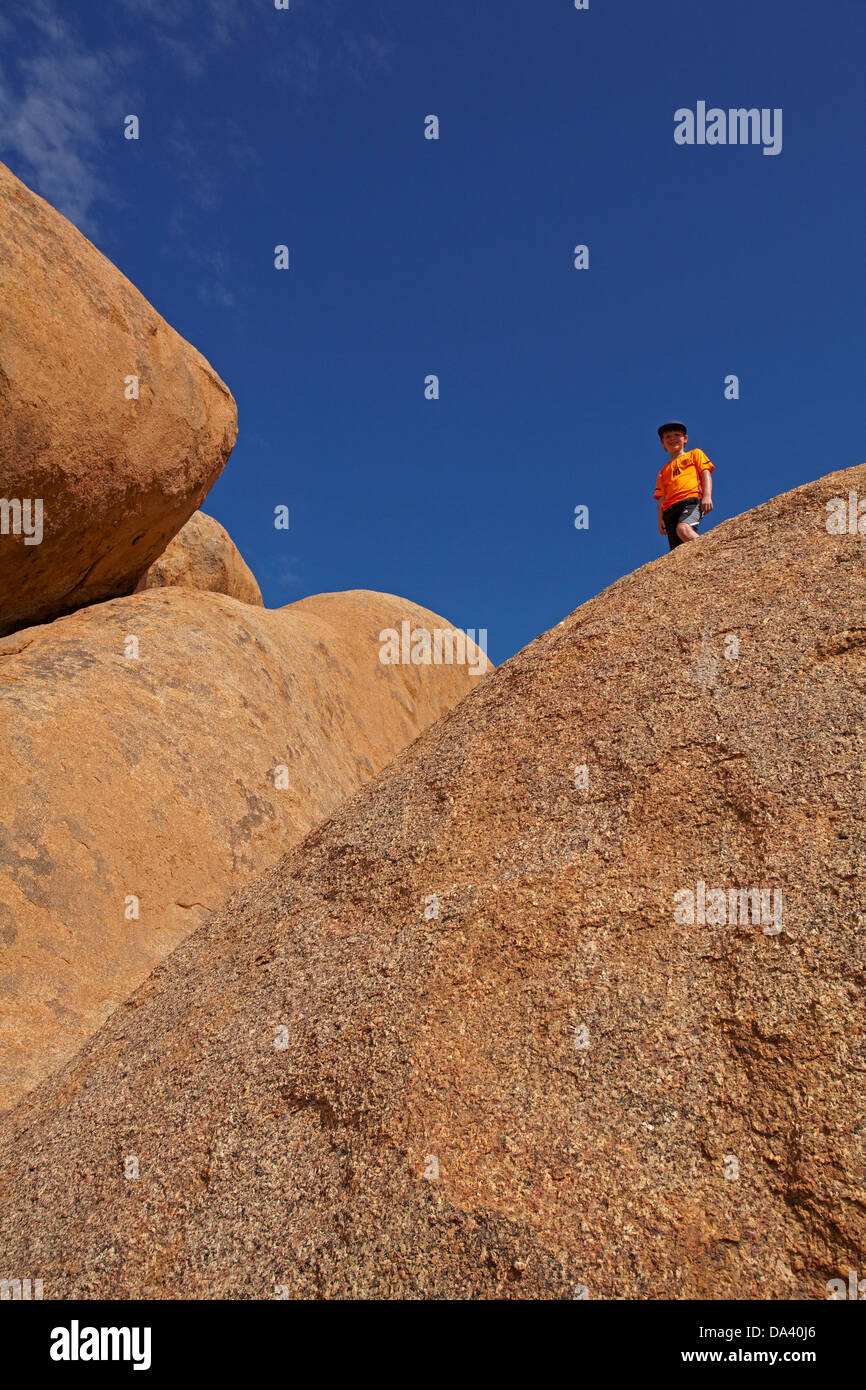 Garçon sur rochers géants à Spitzkoppe, Namibie, Afrique du Sud Banque D'Images