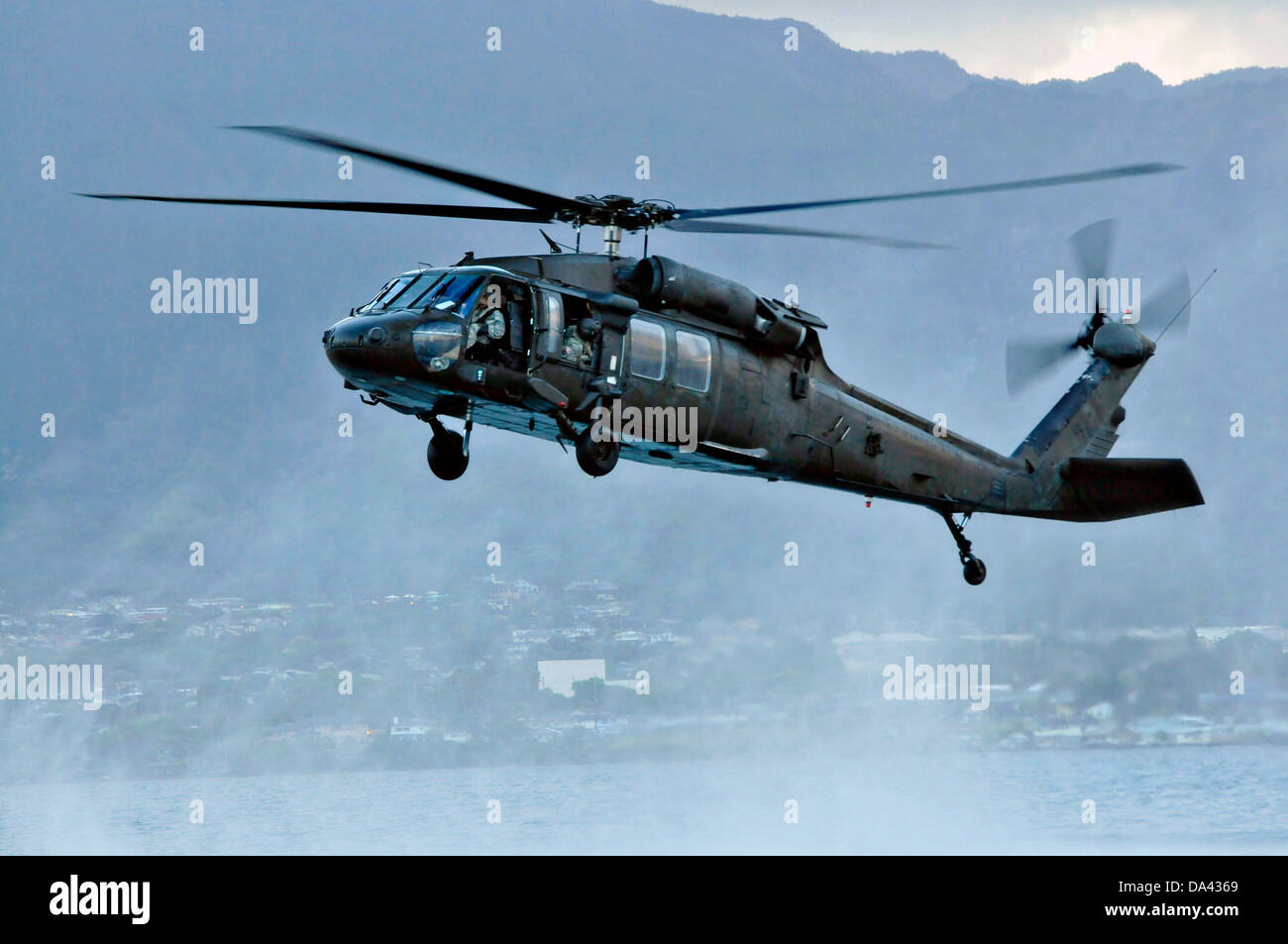 L'Armée américaine UN UH-60 Black Hawk avec la 25e Brigade d'aviation de combat se prépare à déposer le joint de la marine de guerre spéciale Groupe 3 commandos dans l'eau pendant la formation HELOCAST au Marine Corps Air Station Kaneohe Bay le 19 juin 2013 à Hawaii. Banque D'Images