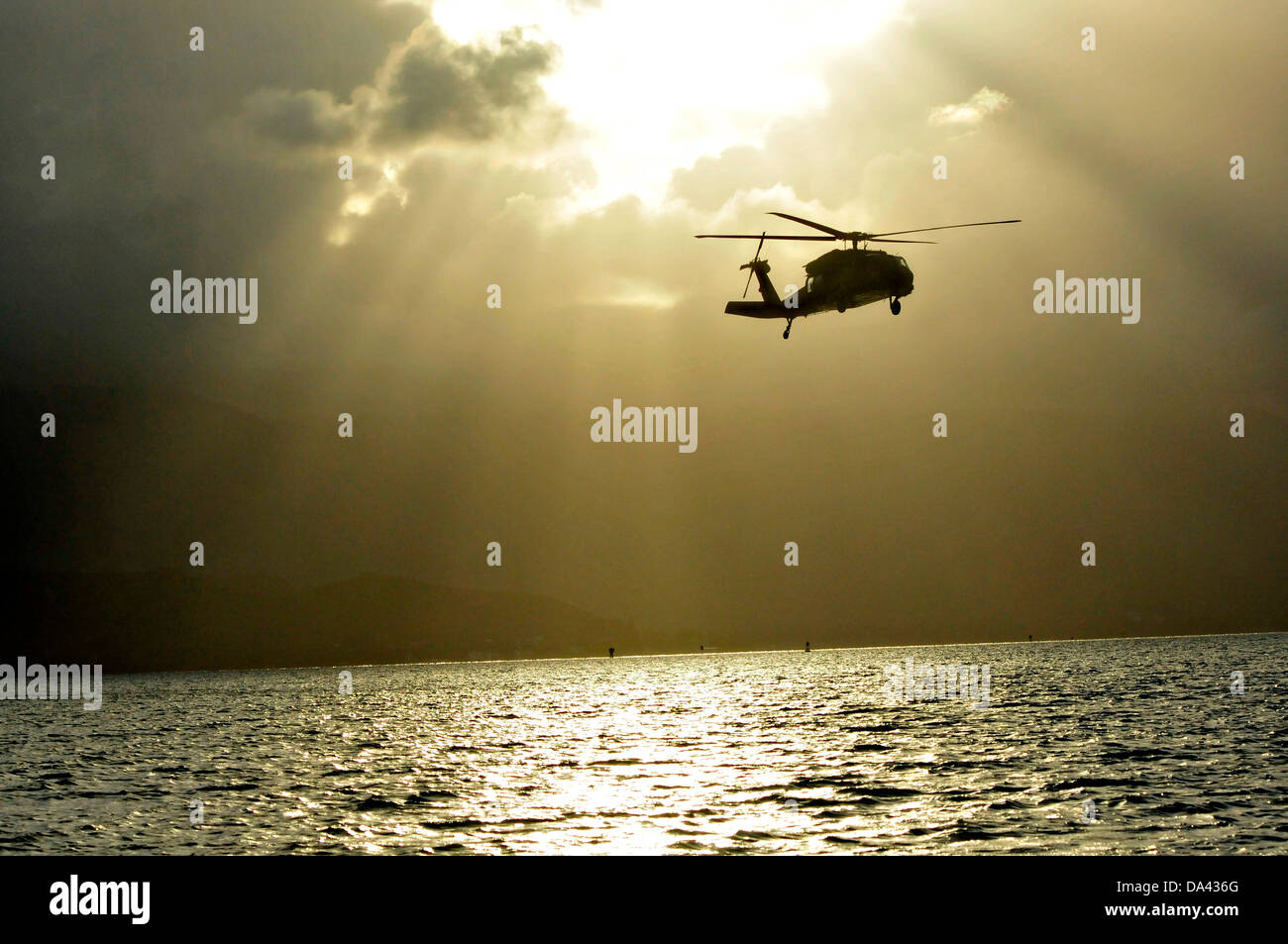 L'Armée américaine UN UH-60 Black Hawk avec la 25e Brigade d'aviation de combat se prépare à déposer le joint de la marine de guerre spéciale Groupe 3 commandos dans l'eau pendant la formation HELOCAST au Marine Corps Air Station Kaneohe Bay le 19 juin 2013 à Hawaii. Banque D'Images