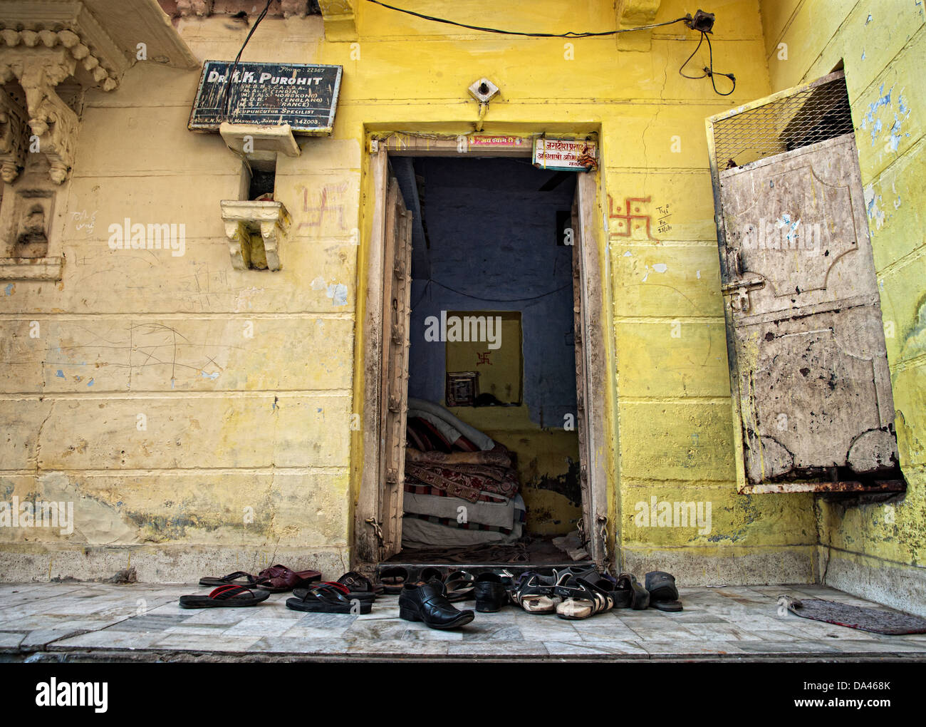 Chaussures devant une porte jaune. Jodhpur, Rajasthan, India Banque D'Images