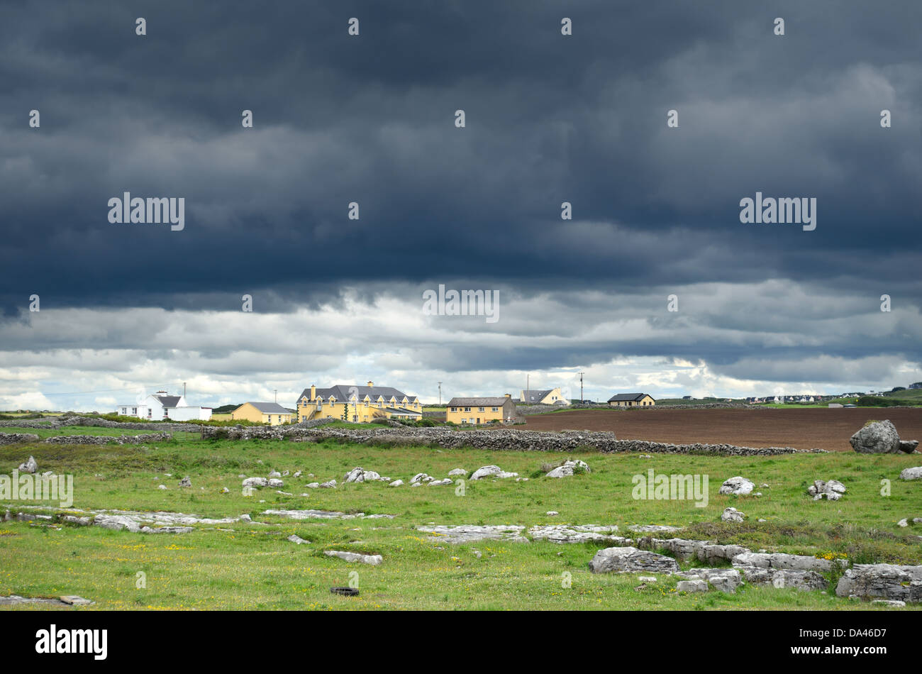 Les nuages noirs et un ciel d'orage sur une petite ville dans le comté de Clare en Irlande de l'Est. Banque D'Images