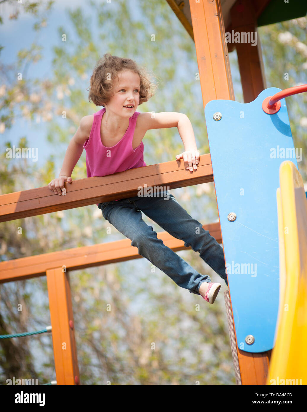 Jeune fille escalade sur le terrain de jeux pour enfants Banque D'Images