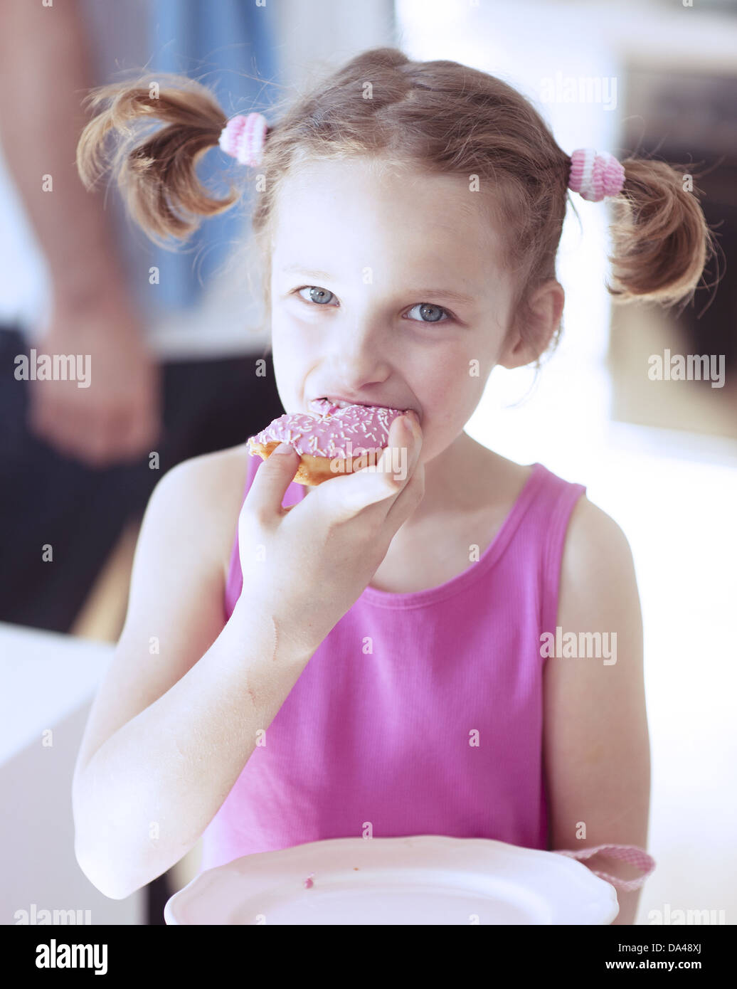 Young Girl eating cake in kitchen Banque D'Images