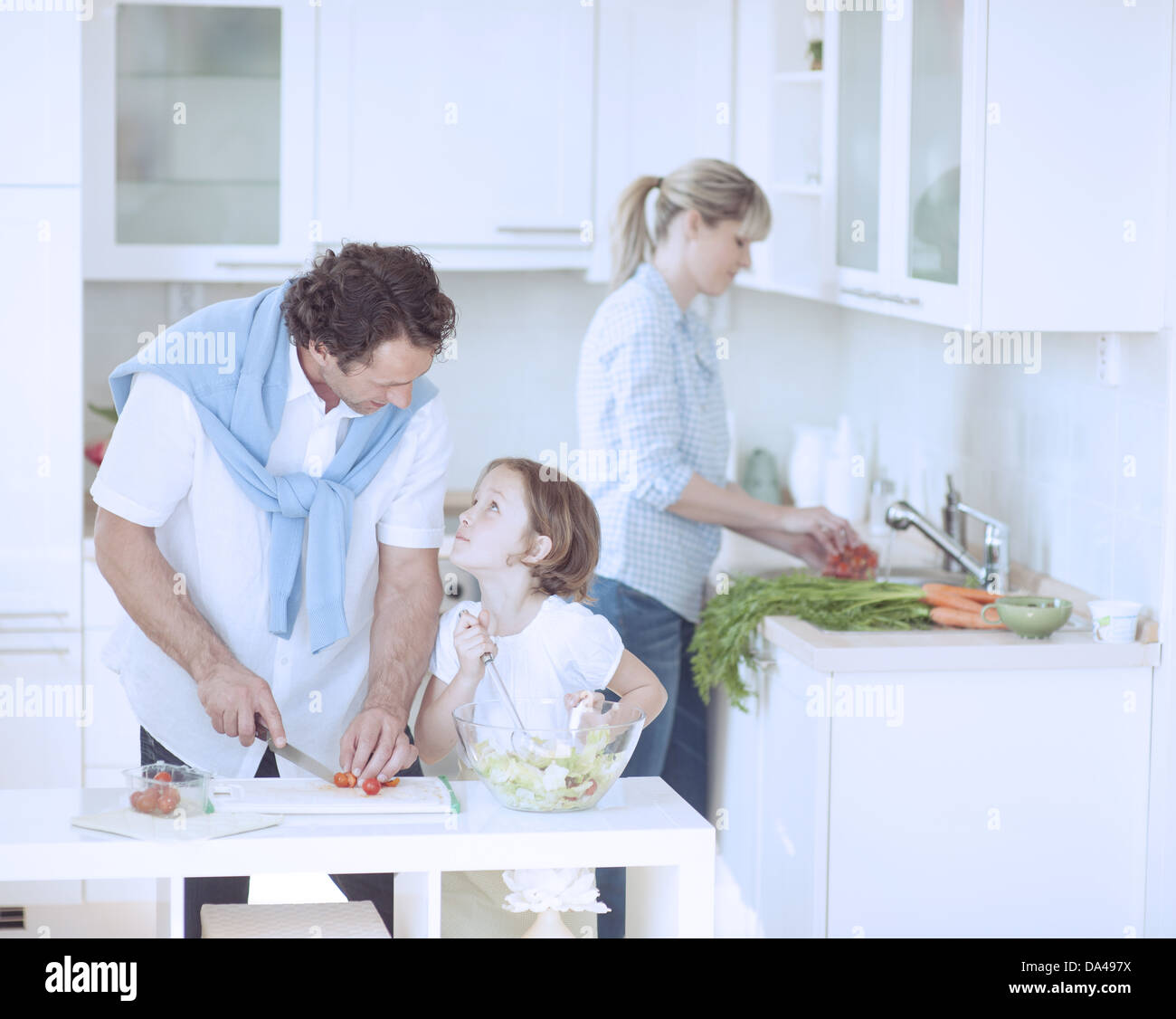 Père et fille à l'un l'autre tout en préparant des repas sains dans la cuisine Banque D'Images