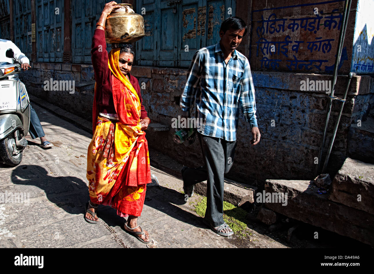 Femme transportant de l'eau sur la tête et marcher dans la rue. Jodhpur, Rajasthan, India Banque D'Images
