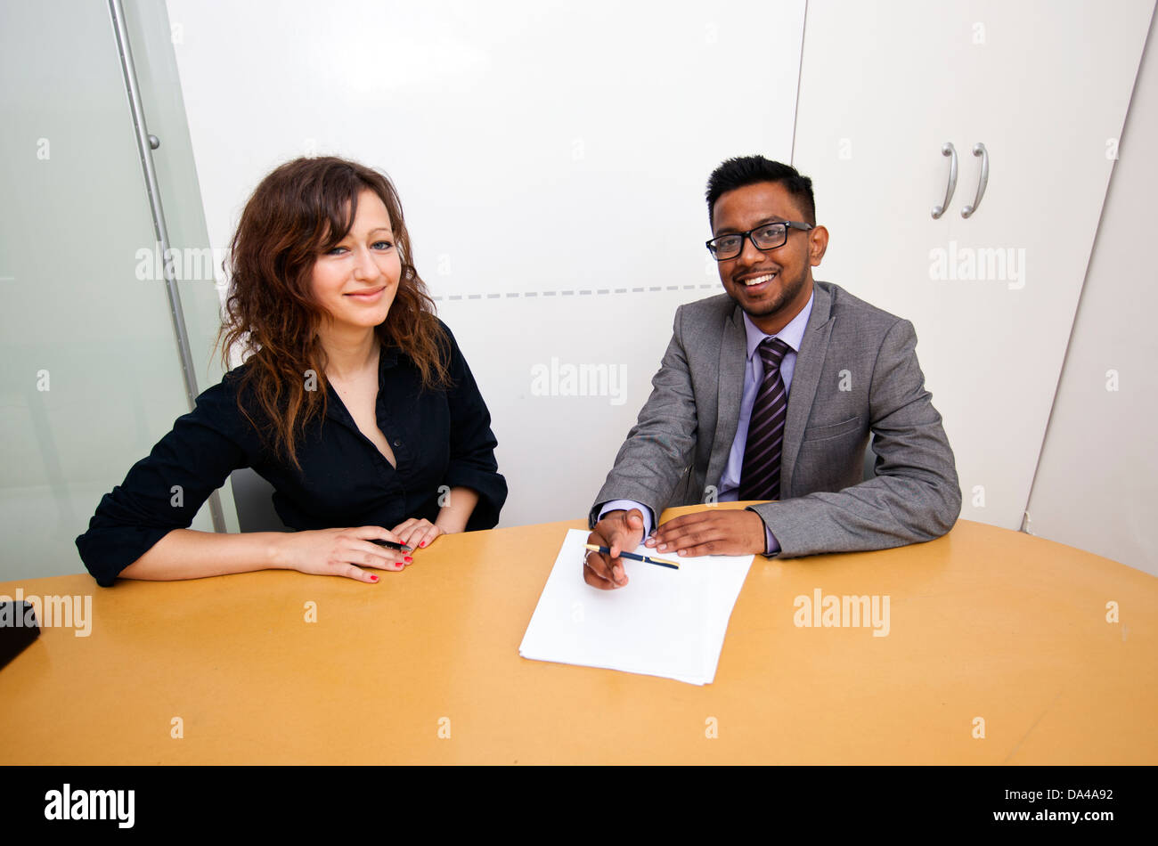 Travail multi-ethnique collègues signer des documents sur une table Banque D'Images