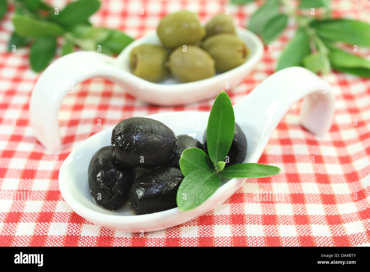 Olives à feuilles d'olivier sur une cuillère Banque D'Images