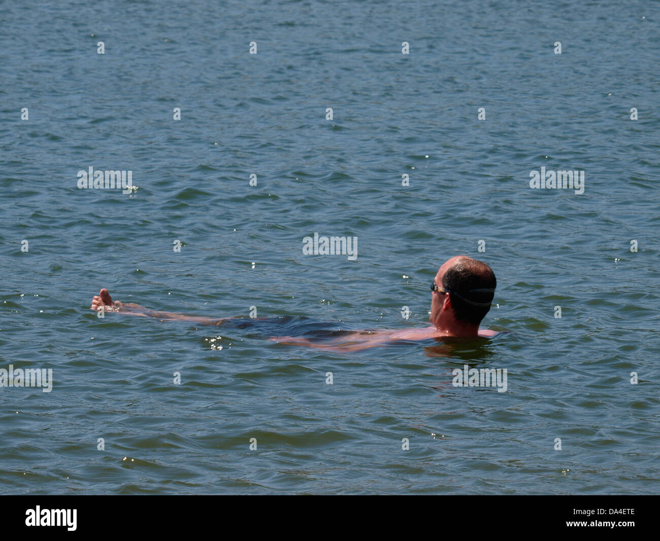 Homme d'âge moyen flottant dans la mer, Devon, UK 2013 Banque D'Images