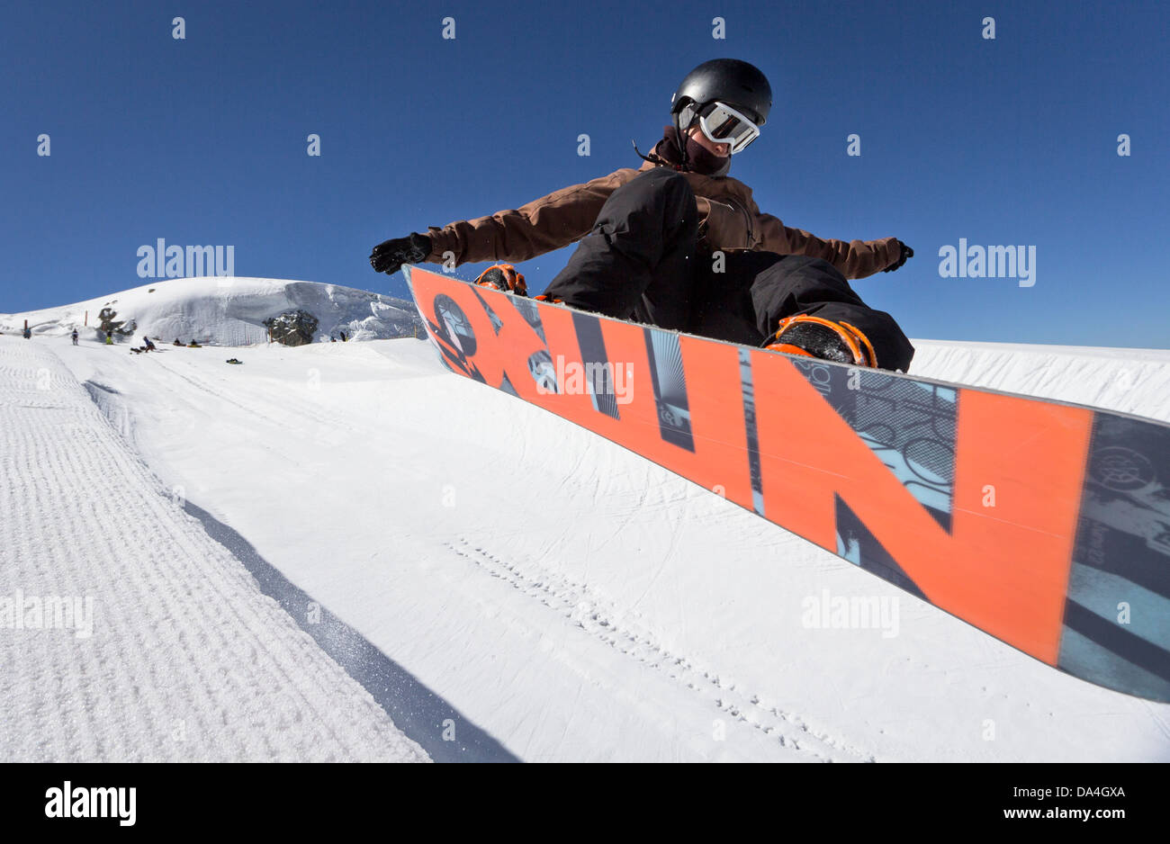 Un snowboarder jumping ist dans un halfpipe à l'été sur le glacier du Théodule snowpark à Zermatt. Banque D'Images