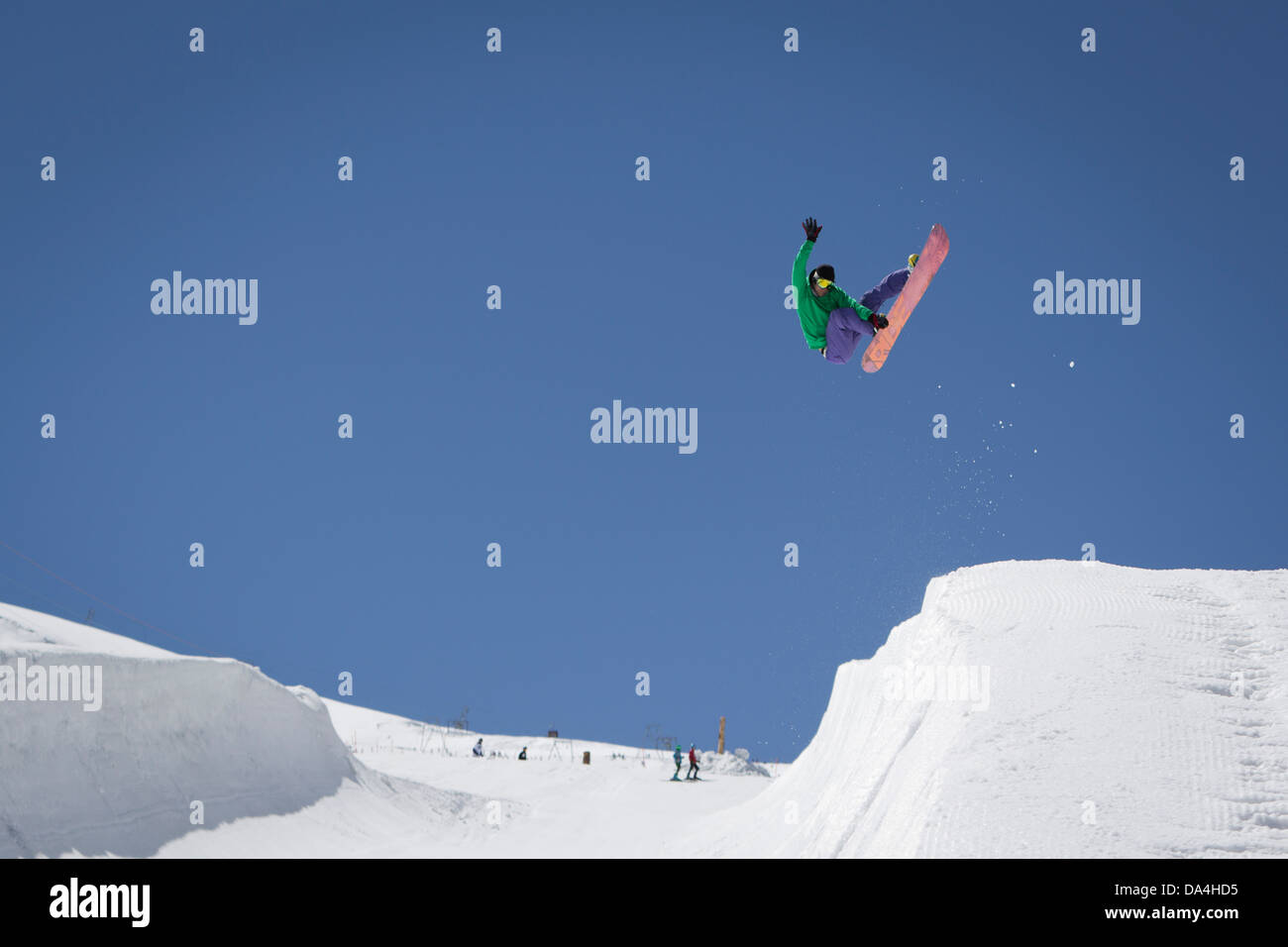 ZERMATT. Un snowboarder riding le halfpipe attrapant le snowboard. Un snowsports photo avec beaucoup d'espace vide. Banque D'Images