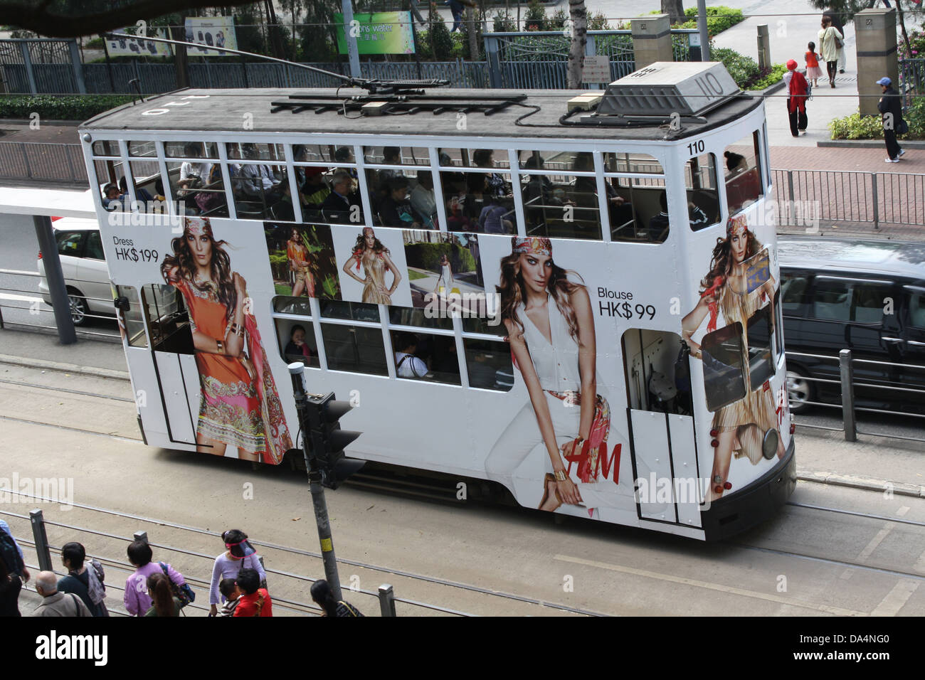 Tramway blanc de Hong Kong avec des modèles de mode portant des articles décontractés exposés sur les côtés du tramway. Tramway électrique à commande aérienne sur le tramway du centre de Hong Kong, Banque D'Images