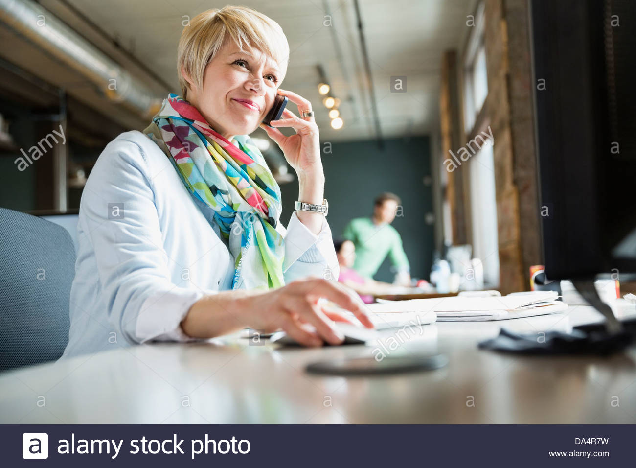 Femme entrepreneur à l'aide de mobile phone at desk Banque D'Images