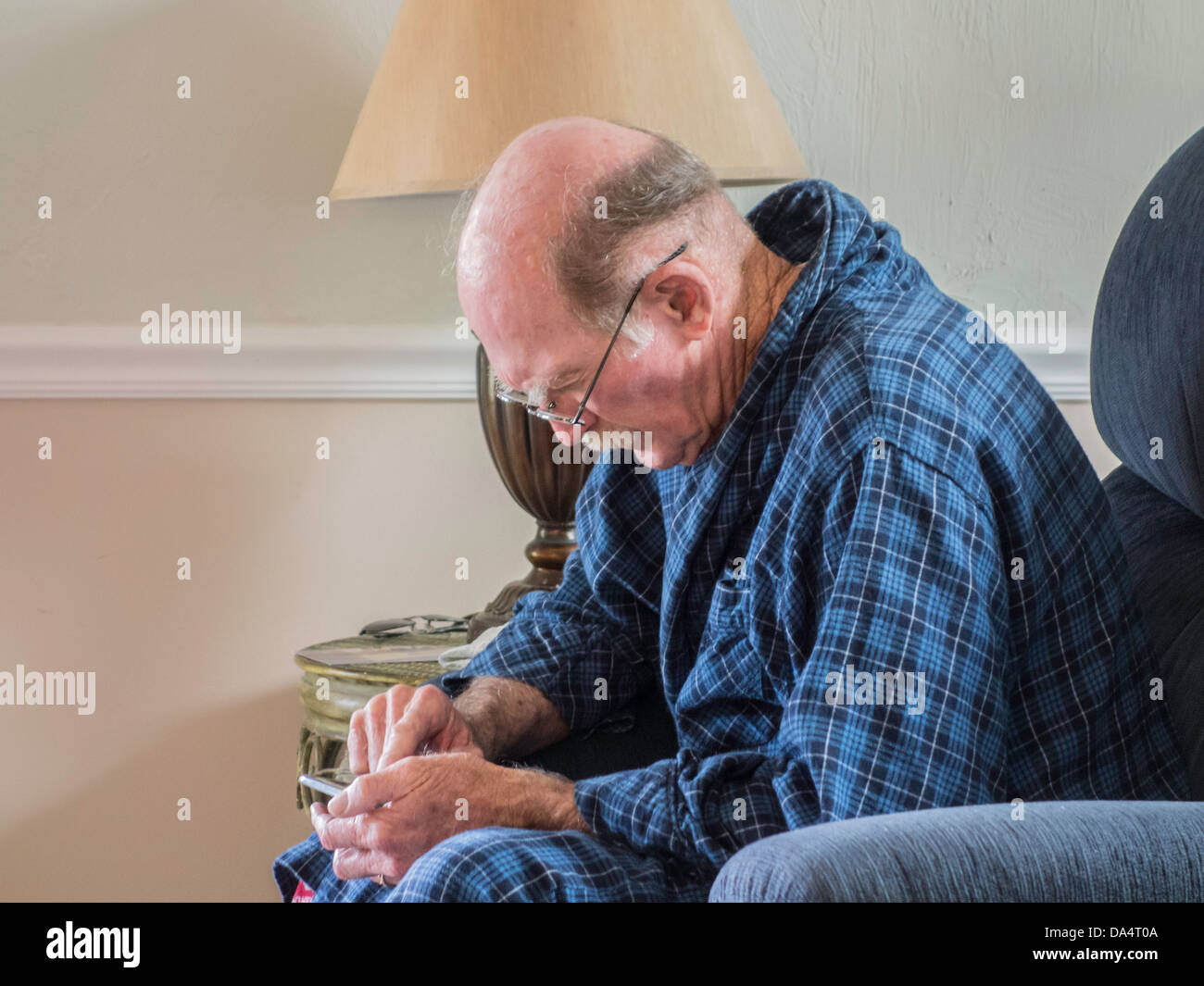 Un homme de 75 ans atteinte de la lutte avec les paramètres de son téléphone cellulaire. USA. Banque D'Images