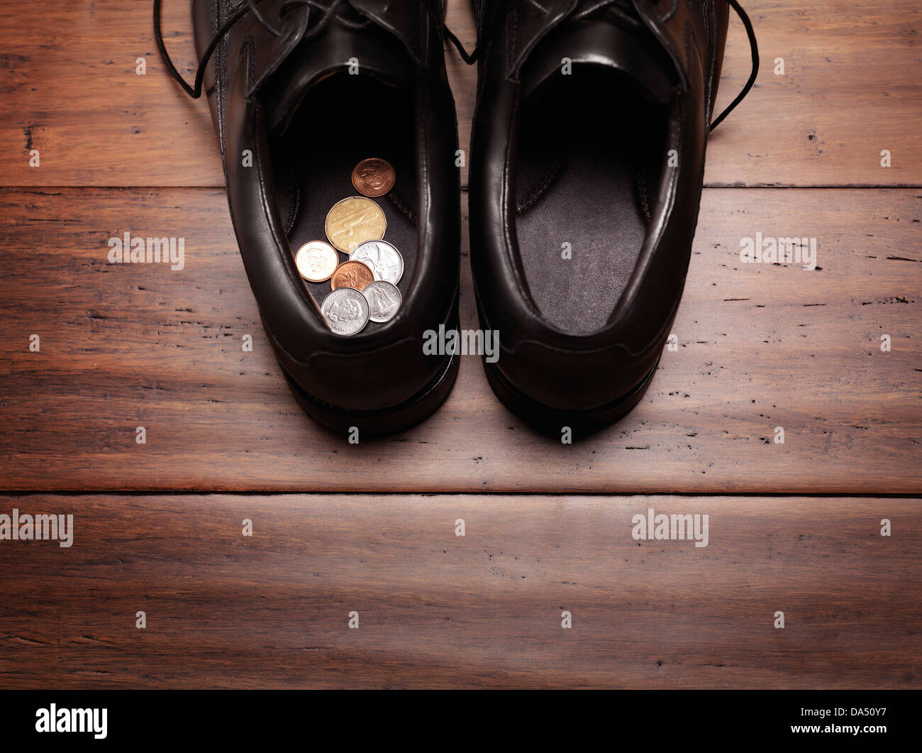 Libre de chaussures pour hommes sur le sol avec des pièces de changement à l'intérieur. Maintenir ou à trouver de l'argent dans un mauvais endroit, concept d'humour. Banque D'Images
