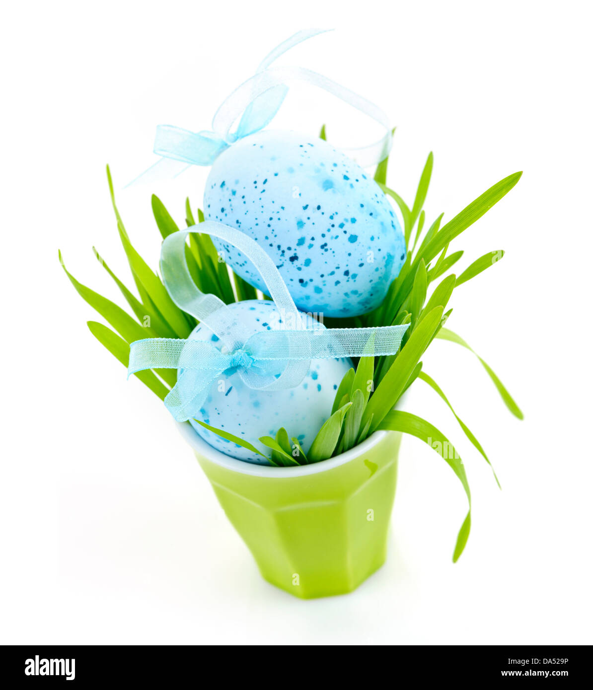 Les oeufs de Pâques bleu disposés en tasse avec de l'herbe verte isolated on white Banque D'Images