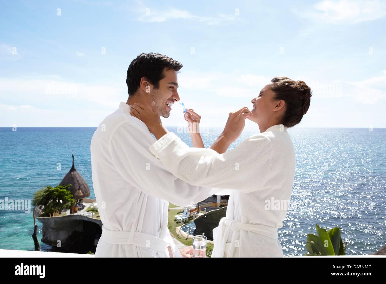 Un couple se brosser les dents sur un balcon. Banque D'Images