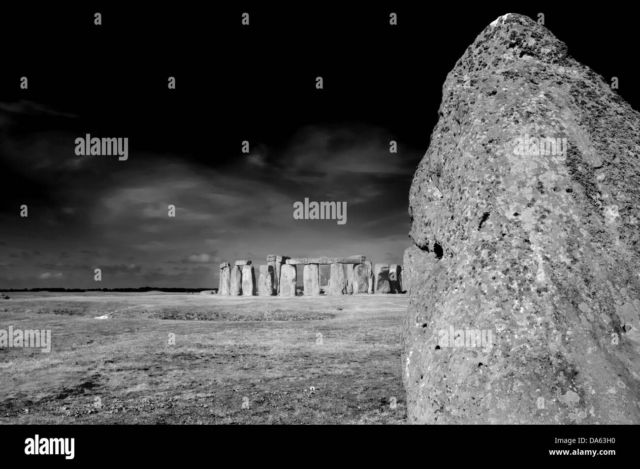 Guérir la pierre avec le reste de Stonehenge en arrière-plan et derrière cette plaine de Salisbury au solstice d'été Banque D'Images