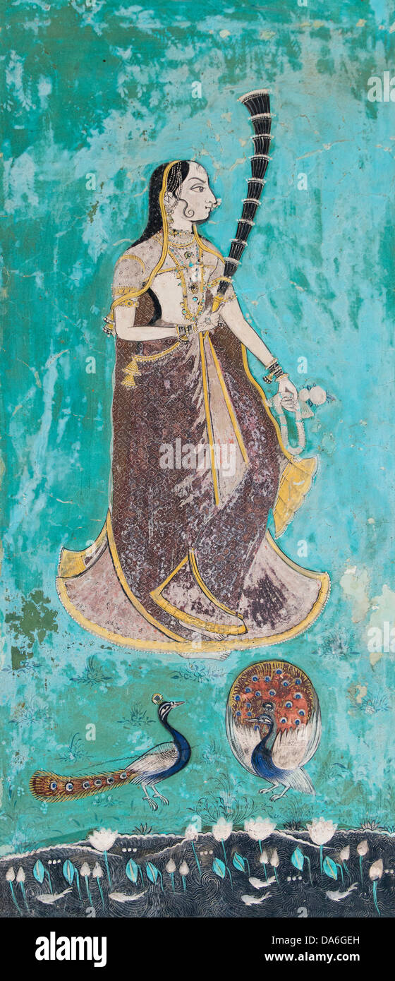 Femme portant un sari doré derrière paons et un étang de lotus, ou peinture murale fresque peinte avec des couleurs naturelles de la Banque D'Images