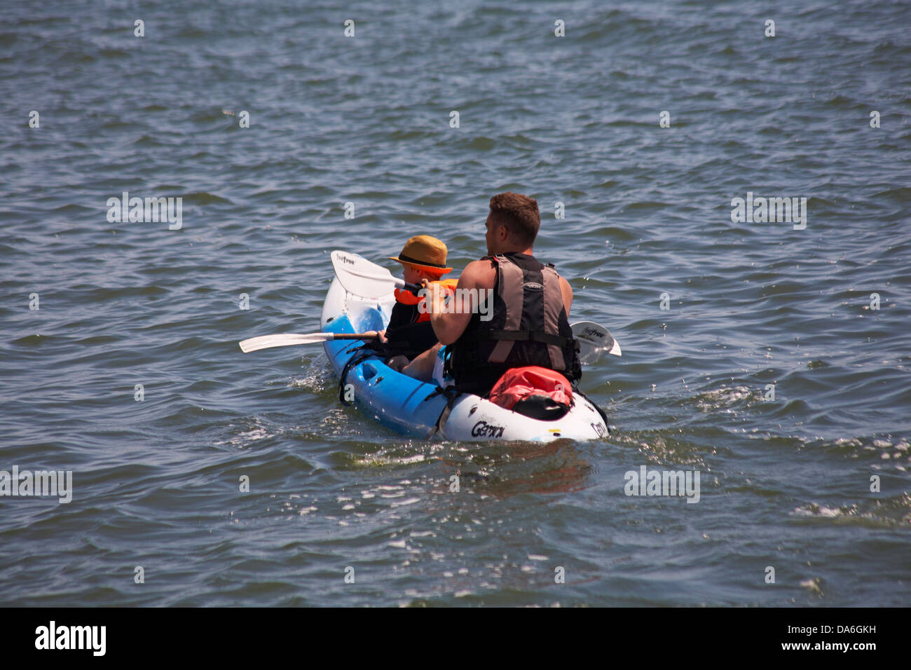 L'homme et le garçon l'aviron en kayak au port de Poole en Juin Banque D'Images