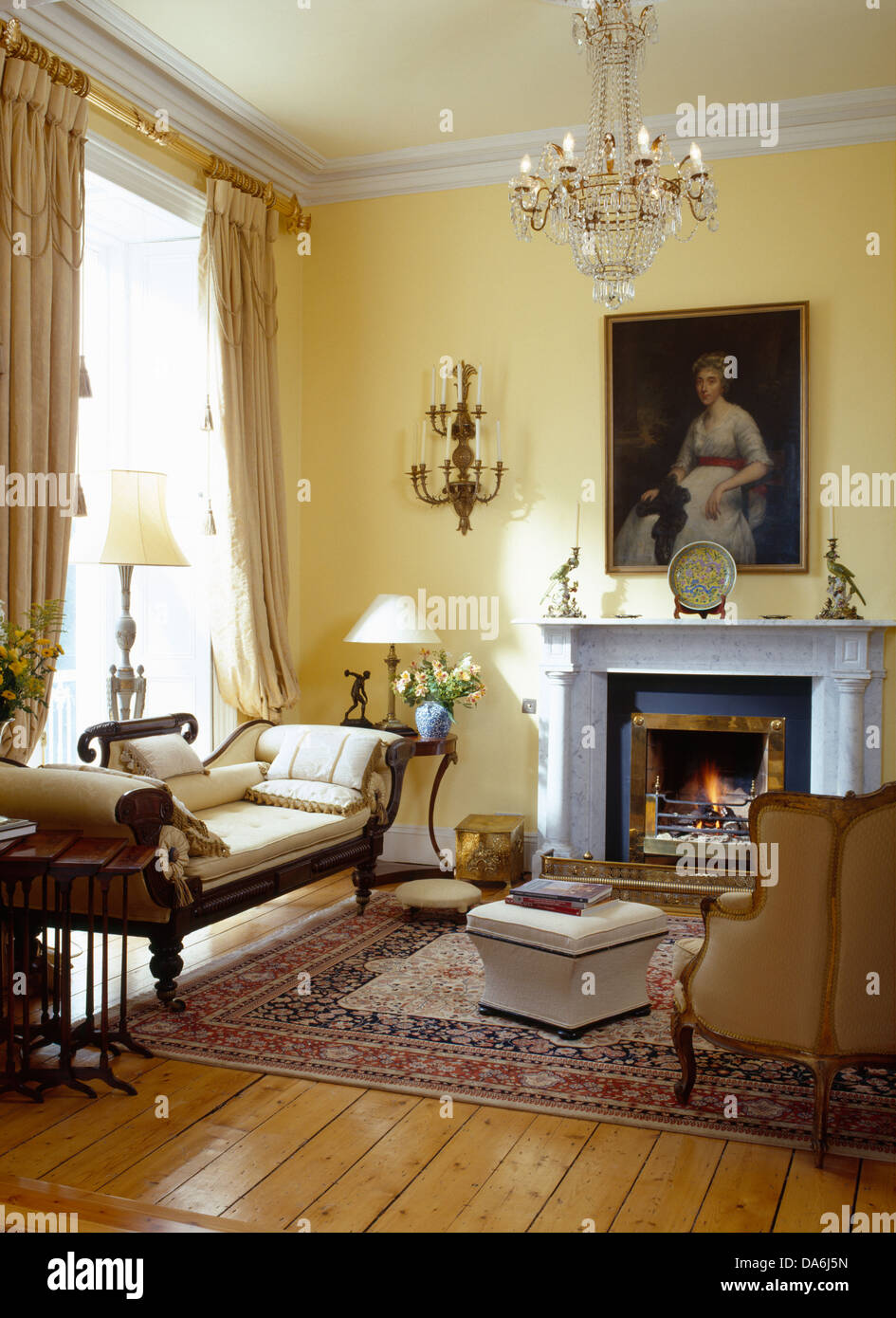 Mobilier chaise longue et parquet dans salon avec grande peinture au-dessus de cheminée en marbre Banque D'Images