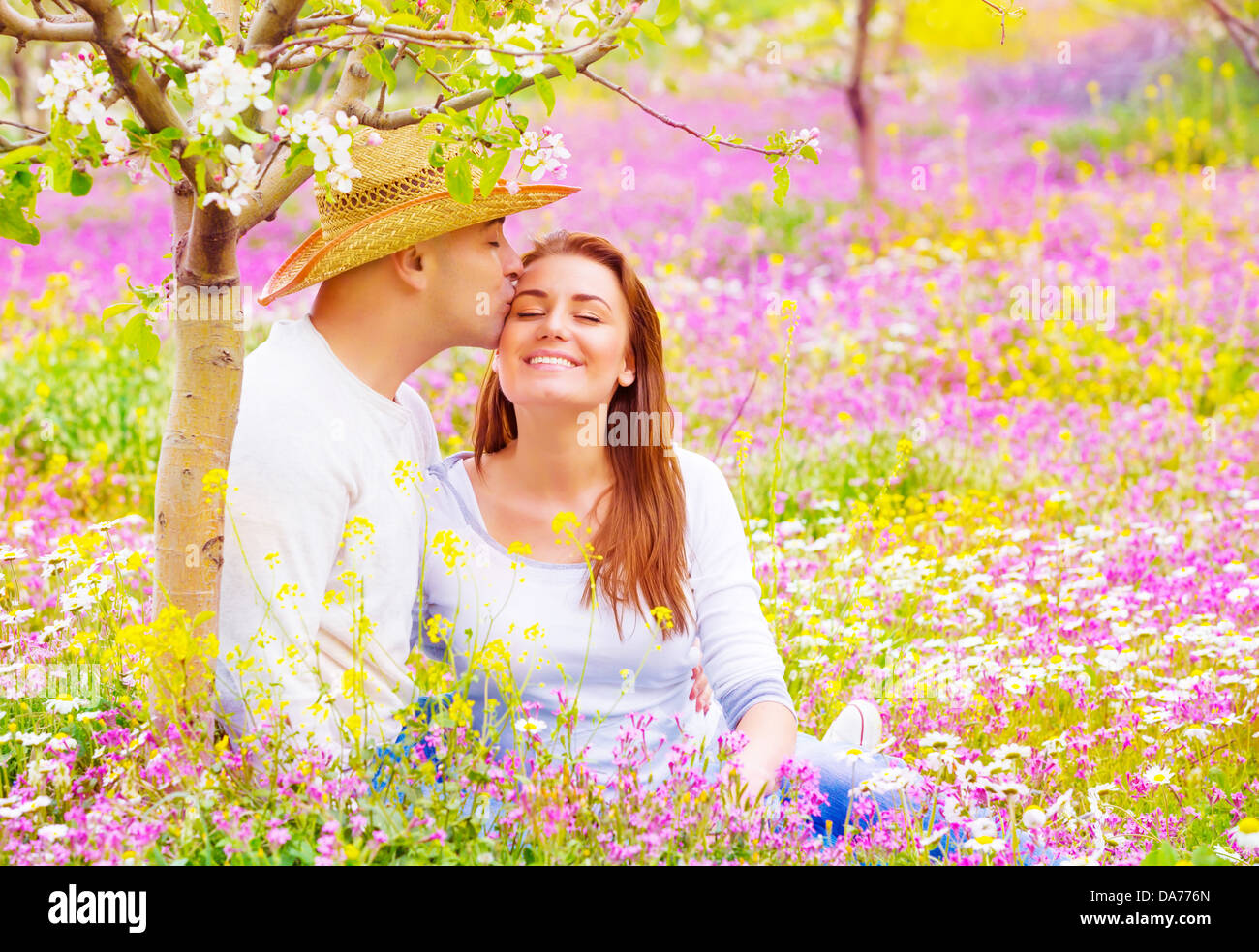 Les amateurs de plein air, les baisers heureux date romantique dans le jardin en fleurs, magnifique jeune famille, l'affection et l'amour concept Banque D'Images