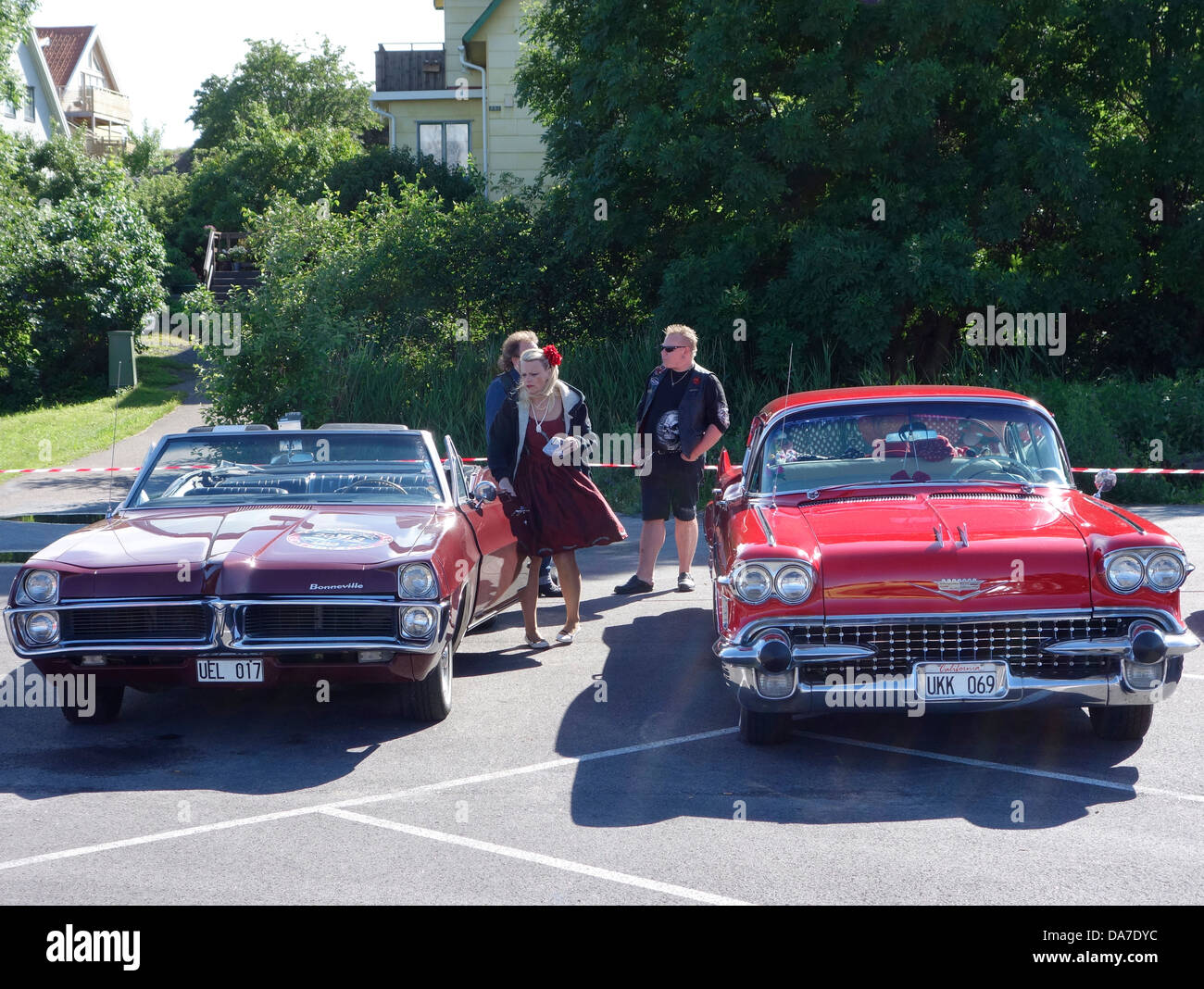 Style Rockabilly femme et homme debout à côté de voitures rétro Pontiac Bonneville et Cadillac Deville (plaques suédois) Banque D'Images