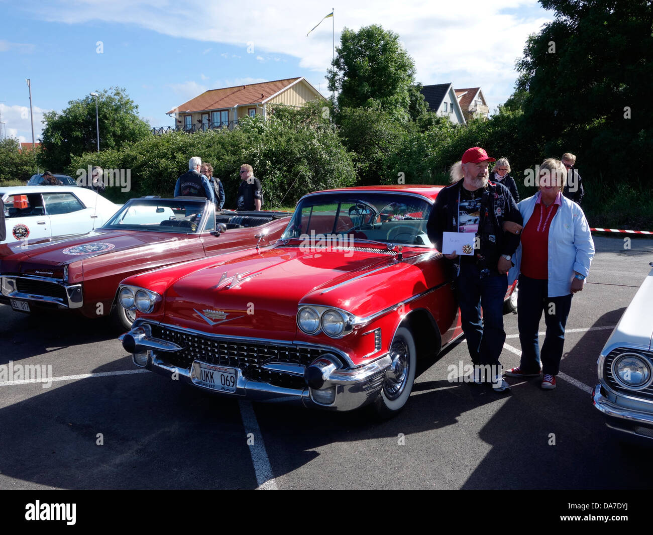 Style Rockabilly femme d'âge moyen et l'homme debout à côté d'une voiture rétro Cadillac Deville (suédois) de la plaque d'immatriculation Banque D'Images