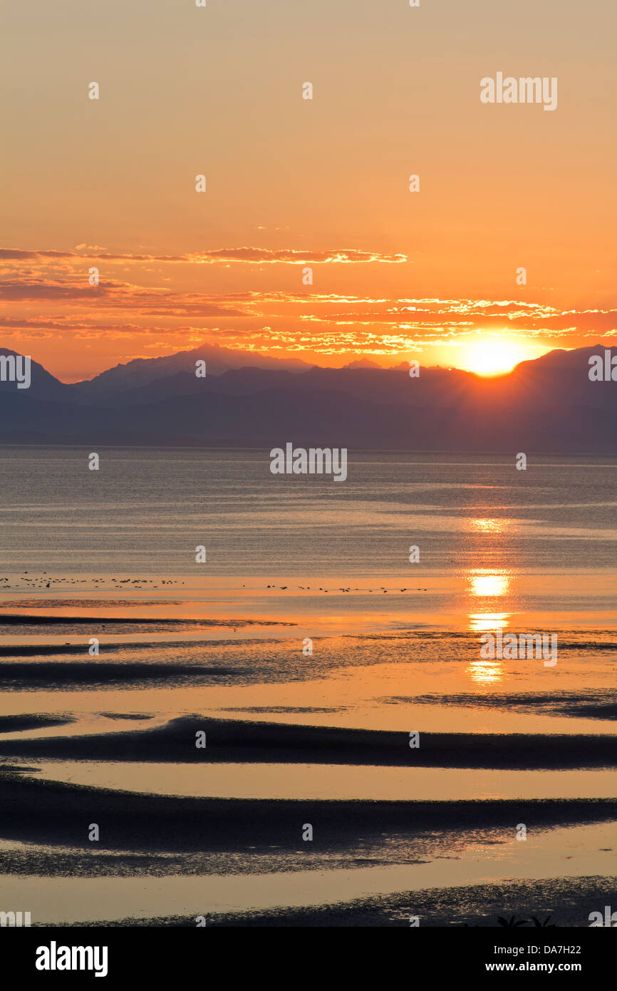 Le lever de soleil sur une plage et des montagnes dans l'île de Vancouver Banque D'Images