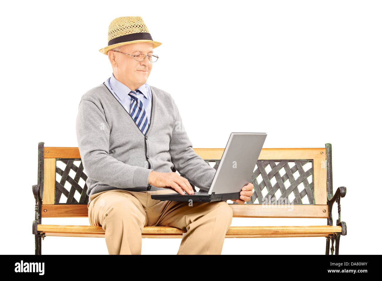 Hauts homme assis sur un banc en bois et de travail sur un ordinateur portable Banque D'Images