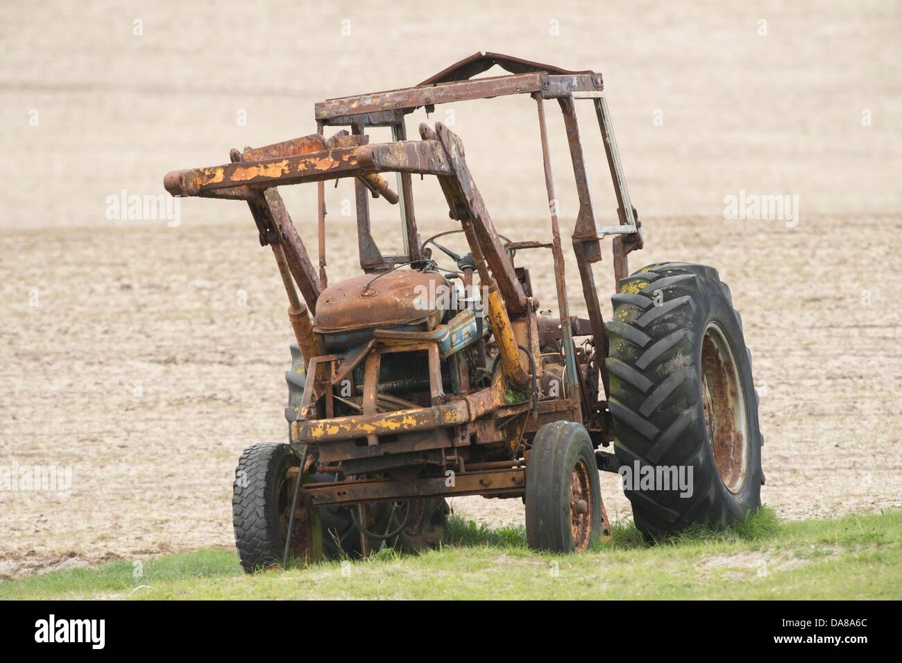 Vieux tracteur agricole laissée à la rouille sous la pluie et le mauvais temps, une corrosion importante a pris une emprise sur le corps de métal tracteurs Banque D'Images