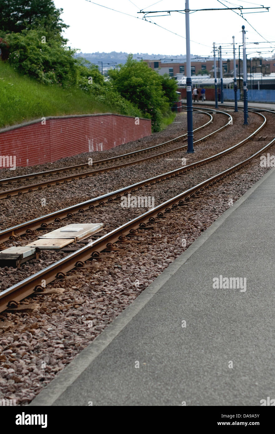 Voies de tram avec deux personnes à distance sur la chaussée Banque D'Images