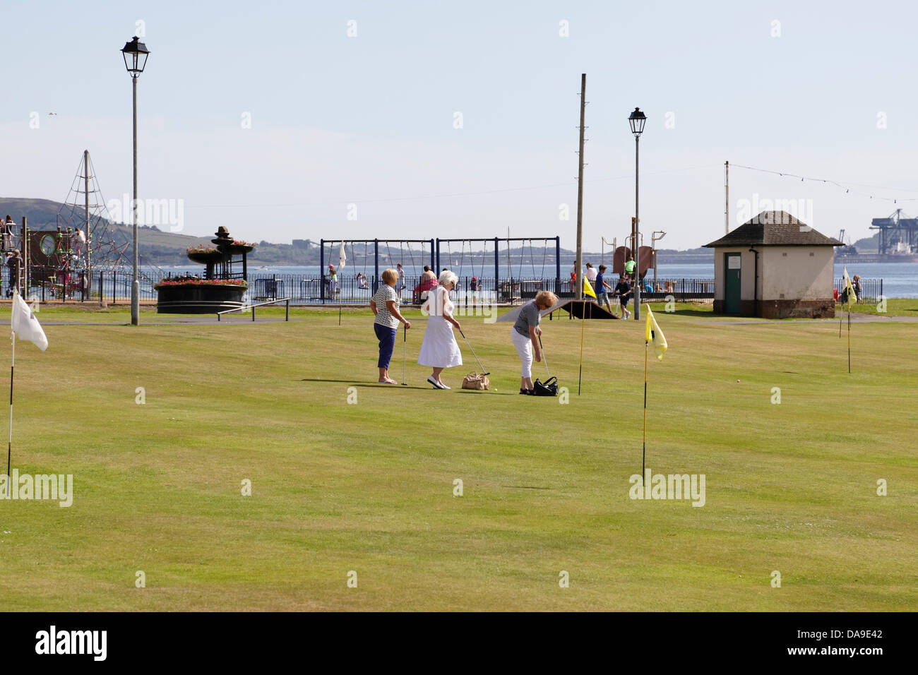 Largs, North Ayrshire, Écosse, Royaume-Uni, lundi, 8 juillet 2013. Les gens qui apprécient une partie de terrain et de putt sur le Mackerston putting Green dans le soleil chaud d'été à côté du Firth of Clyde Banque D'Images