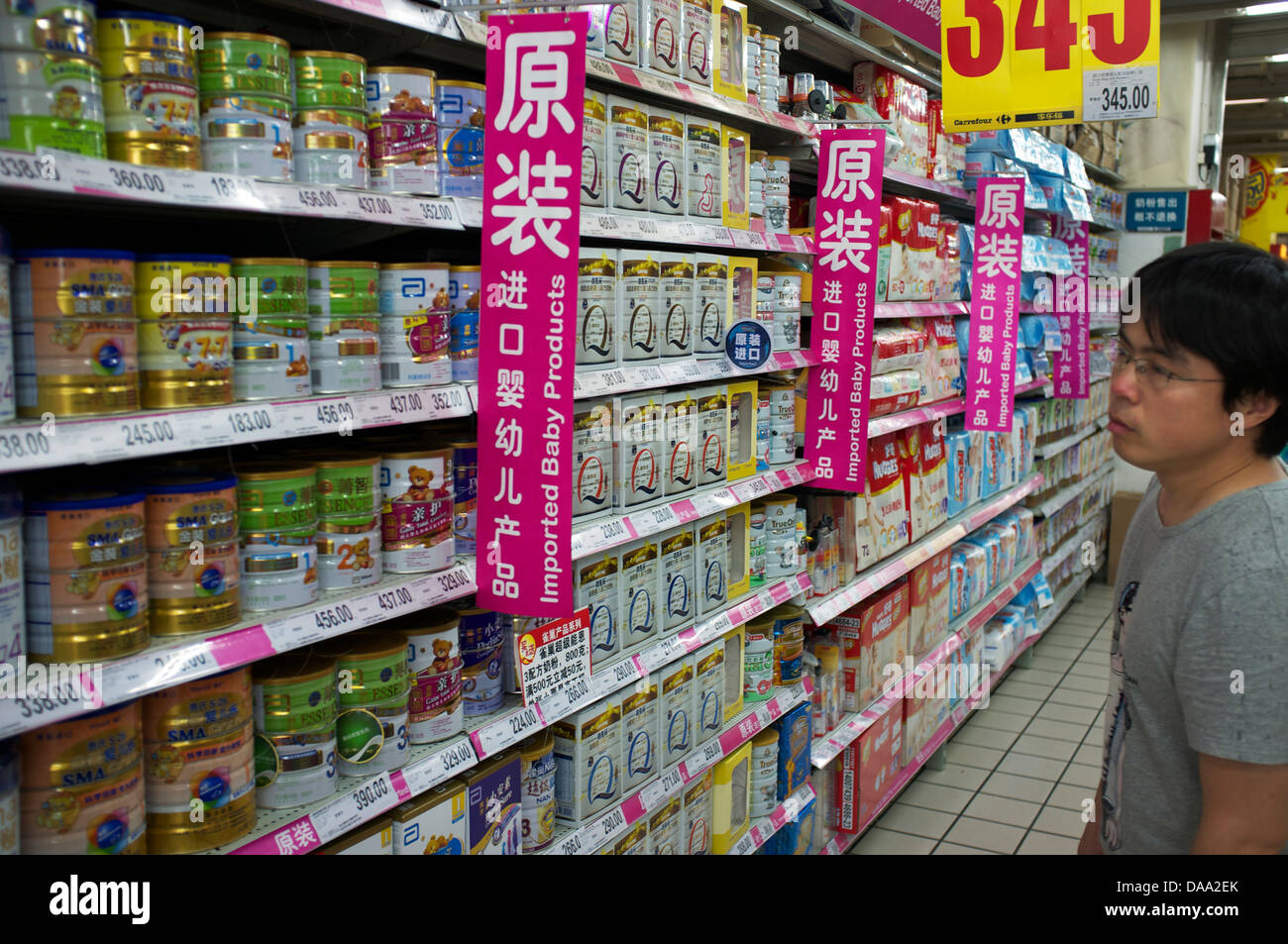 Un homme se penche sur la préparation pour nourrissons importé du lait en poudre pour bébé dans un supermarché de Pékin, Chine. 09-Jul-2013 Banque D'Images