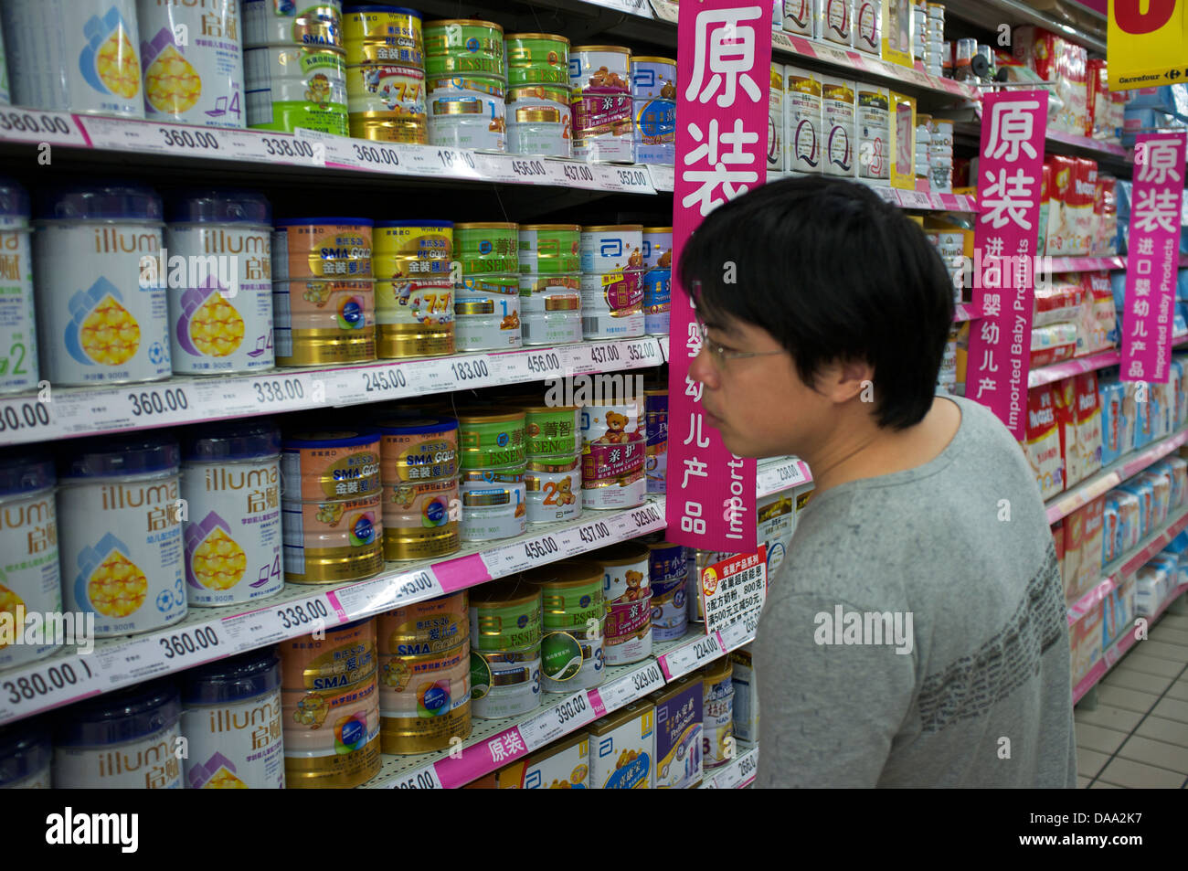 Un homme se penche sur la préparation pour nourrissons importé du lait en poudre pour bébé dans un supermarché de Pékin, Chine. 09-Jul-2013 Banque D'Images