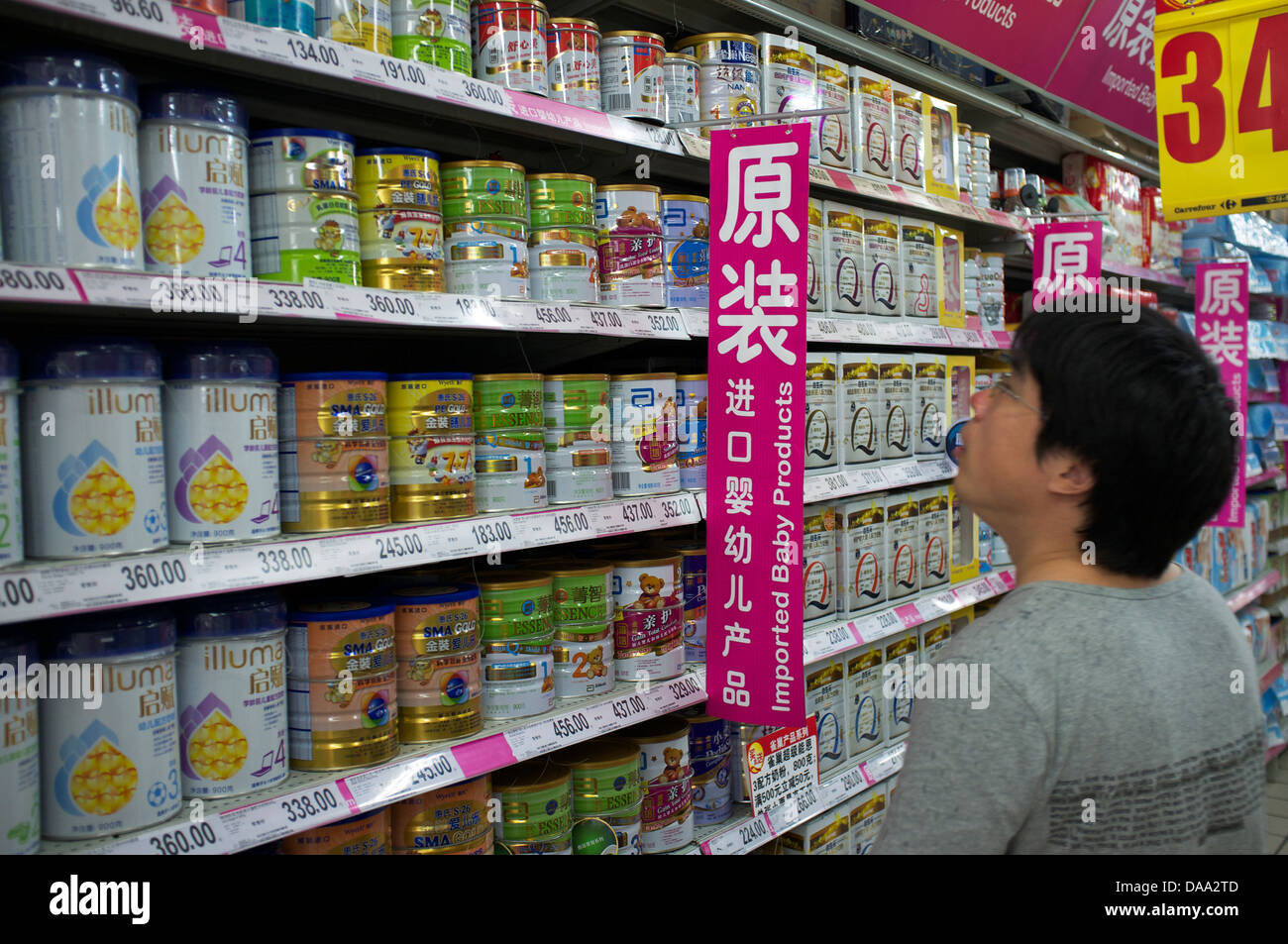 Un homme se penche sur la préparation pour nourrissons importé du lait en poudre pour bébé dans un supermarché de Pékin, Chine. 09-Jul-2013 Banque D'Images