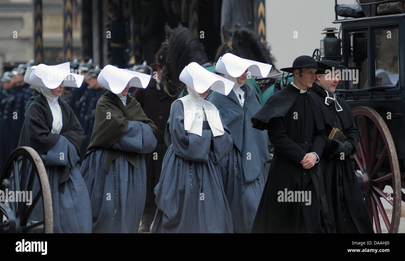 Le port de vêtements traditionnels extras à pied à travers l'Muensterplatz pendant un tournage du film hollywoodien Sherlock Holmes 2' à Strasbourg, France, 02 février 2011. Le film du réalisateur britannique Guy Ritchie l'est réglé en 1890, lorsque l'Alsace appartenait à l'Empire allemand. Le film est prévu d'arriver des cinémas à la fin de 2011. Photo : Ronald Wittek Banque D'Images