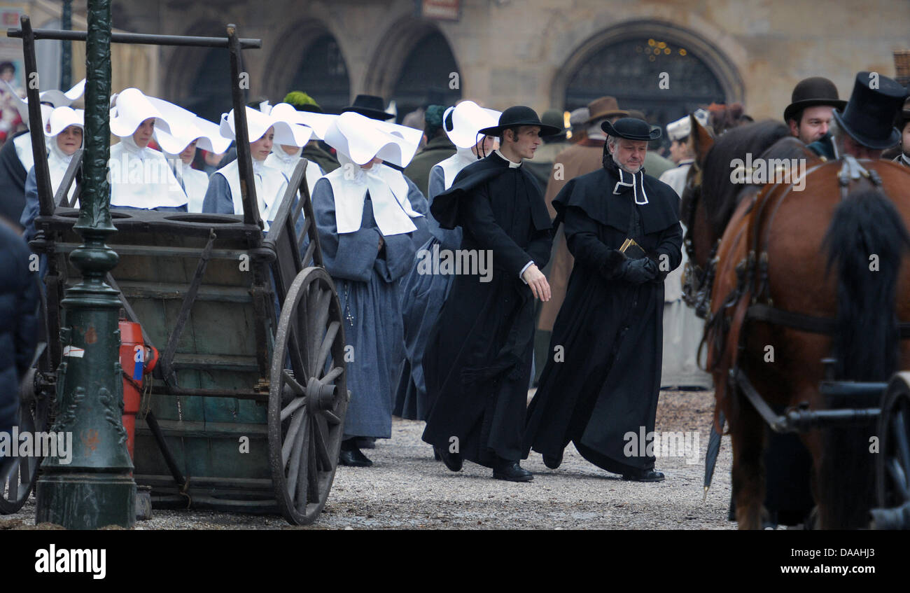 Le port de vêtements traditionnels extras à pied à travers l'Muensterplatz pendant le tournage du film hollywoodien Sherlock Holmes 2' à Strasbourg, France, 02 février 2011. Le film du réalisateur britannique Guy Ritchie l'est réglé en 1890, lorsque l'Alsace appartenait à l'Empire allemand. Le film est prévu d'arriver des cinémas à la fin de 2011. Photo : Ronald Wittek Banque D'Images