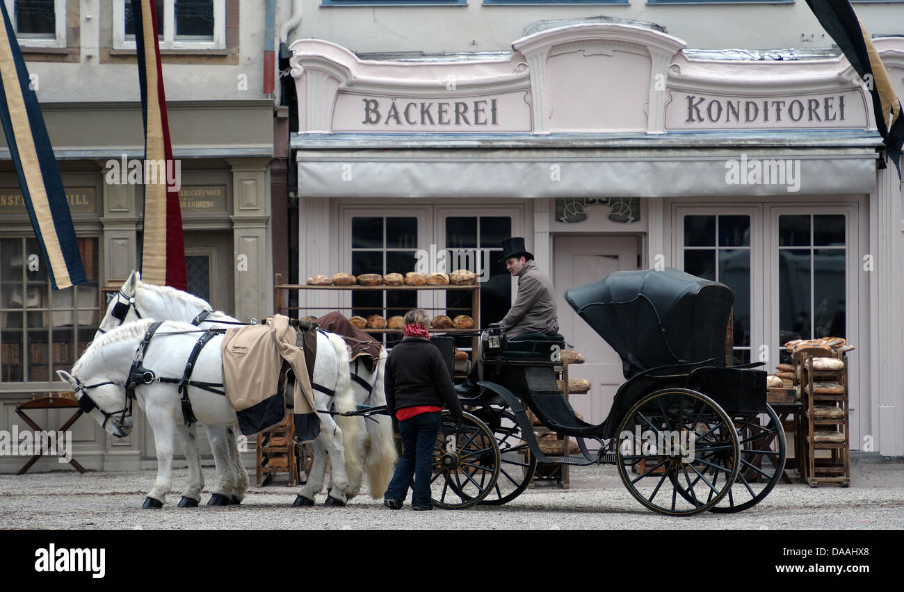 Un supplément de porter des vêtements historiques se trouve dans un chariot à cheval à l'Muensterplatz au cours d'une fusillade du film hollywoodien Sherlock Holmes 2' à Strasbourg, France, 02 février 2011. Le film du réalisateur britannique Guy Ritchie l'est réglé en 1890, lorsque l'Alsace appartenait à l'Empire allemand. Le film est prévu d'arriver des cinémas à la fin de 2011. Photo : Ronald Wittek Banque D'Images