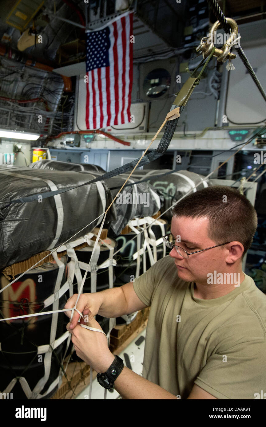 Le s.. Derek Johnson, 451e Escadron de soutien des opérations expéditionnaires, arrimeur de forage une ligne statique sur un parachute C-17A Globemaster III pour un largage hors de l'aérodrome de Kandahar, Afghanistan, le 27 juin 2013. L'équipage a effectué deux largages Globemaster Banque D'Images Le s.. Derek Johnson, 451e Escadron de soutien des opérations expéditionnaires, arrimeur de forage une ligne statique sur un parachute C-17A Globemaster III pour un largage hors de l'aérodrome de Kandahar, Afghanistan, le 27 juin 2013. L'équipage a effectué deux largages Globemaster Banque D'Images