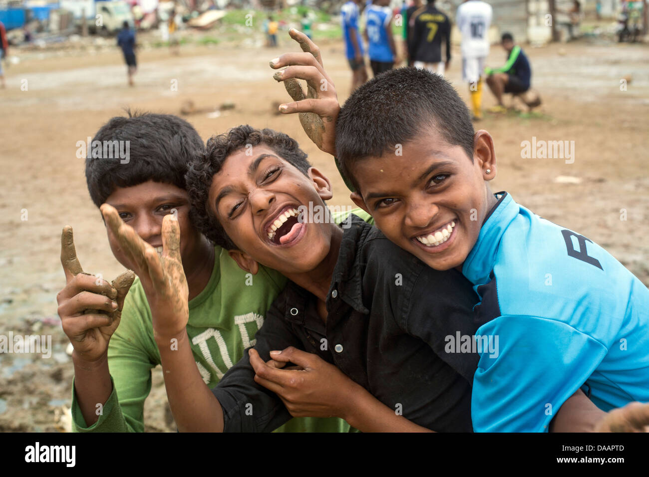 Les pêcheurs de Mumbai et leurs enfants jouer au cricket tandis que le temps de la mousson les arrête la pêche sur la masse des déchets derrière les taudis. Banque D'Images