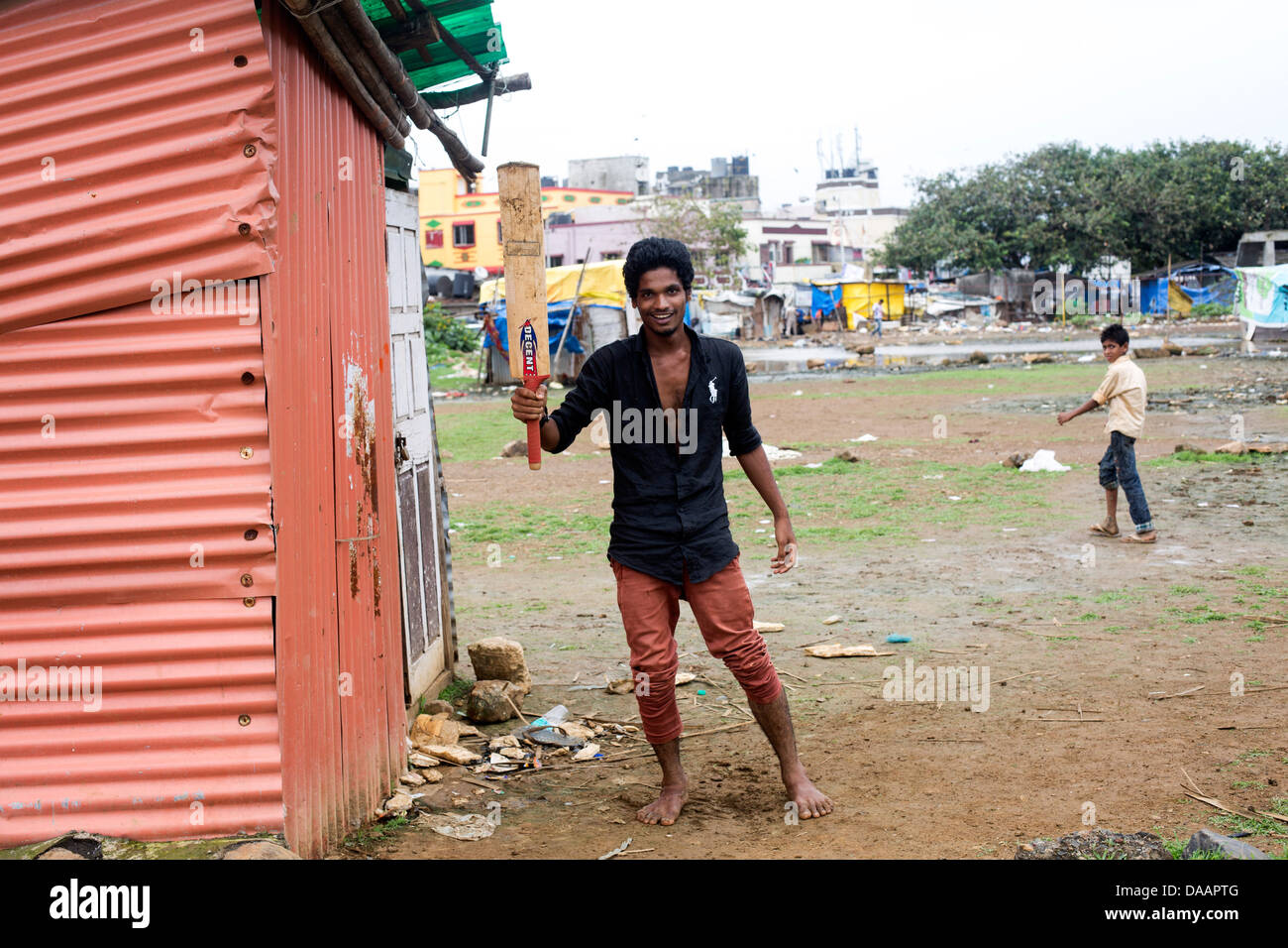 Les pêcheurs de Mumbai et leurs enfants jouer au cricket tandis que le temps de la mousson les arrête la pêche sur la masse des déchets derrière les taudis. Banque D'Images